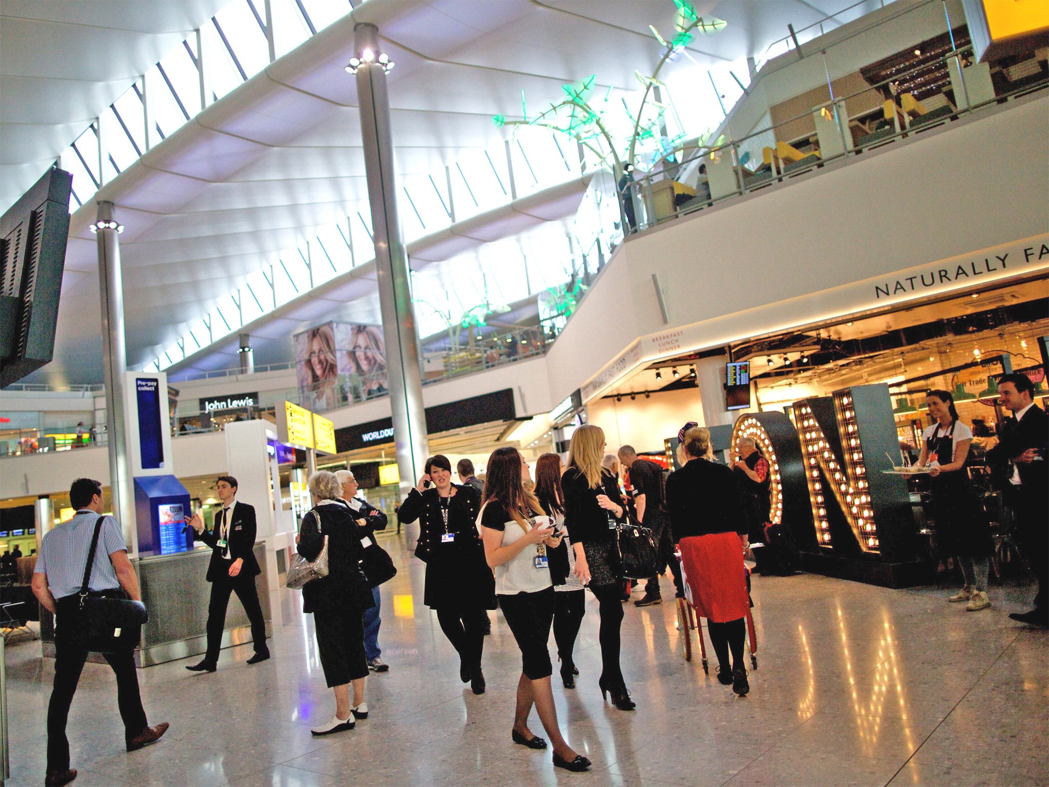Passengers walk around the shops and restaurants in the new Terminal 2 at Heathrow Airport