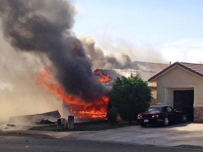 Flames and smoke billowing from a civilian's house after a US military airplane crashed in Imperial, California, USA, 04 June 2014.
