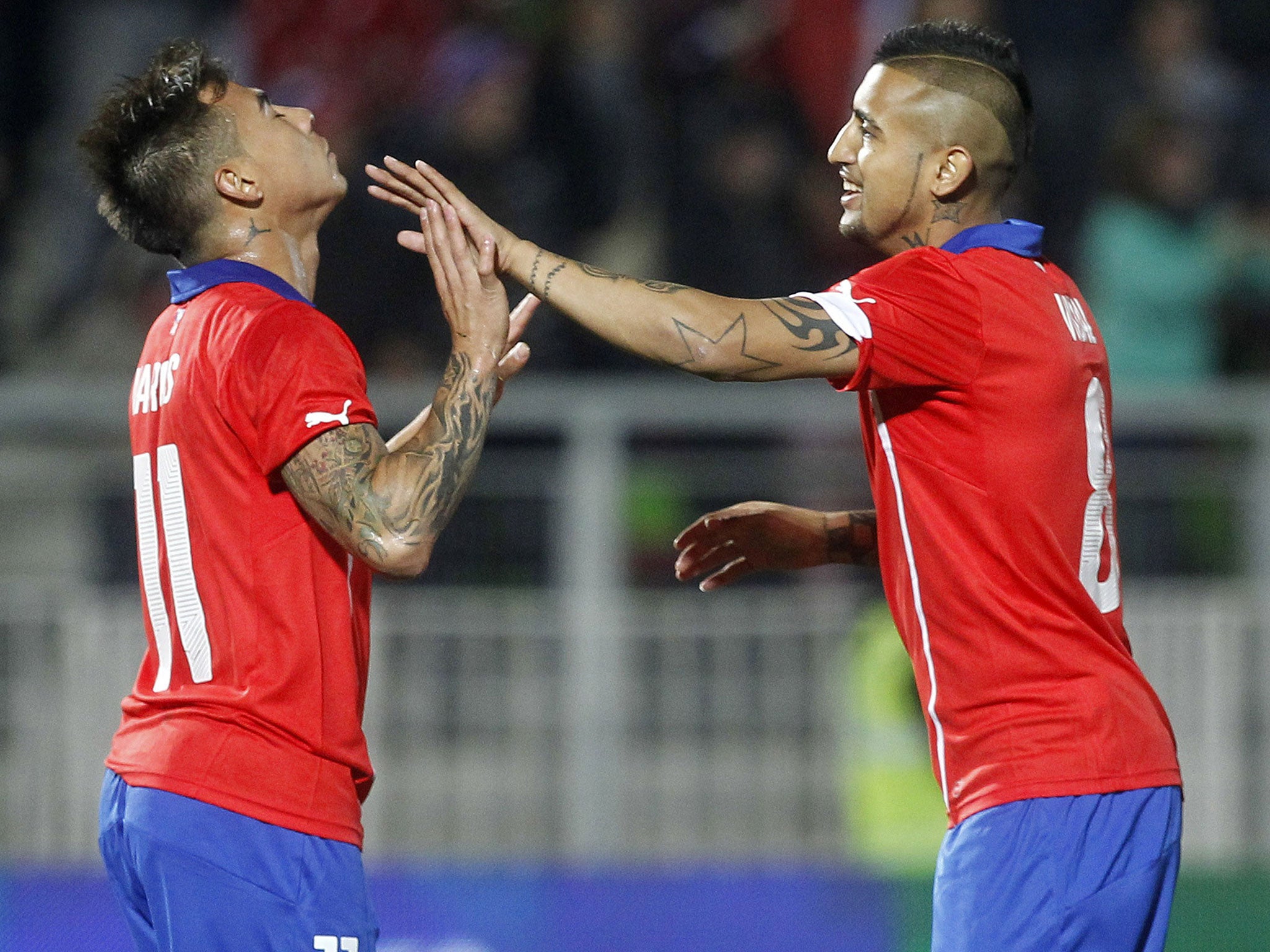 Chilean national team footballer Eduardo Vargas (L) celebrates next to Arturo Vidal after scoring against North Ireland during a friendly football match in Valparaiso