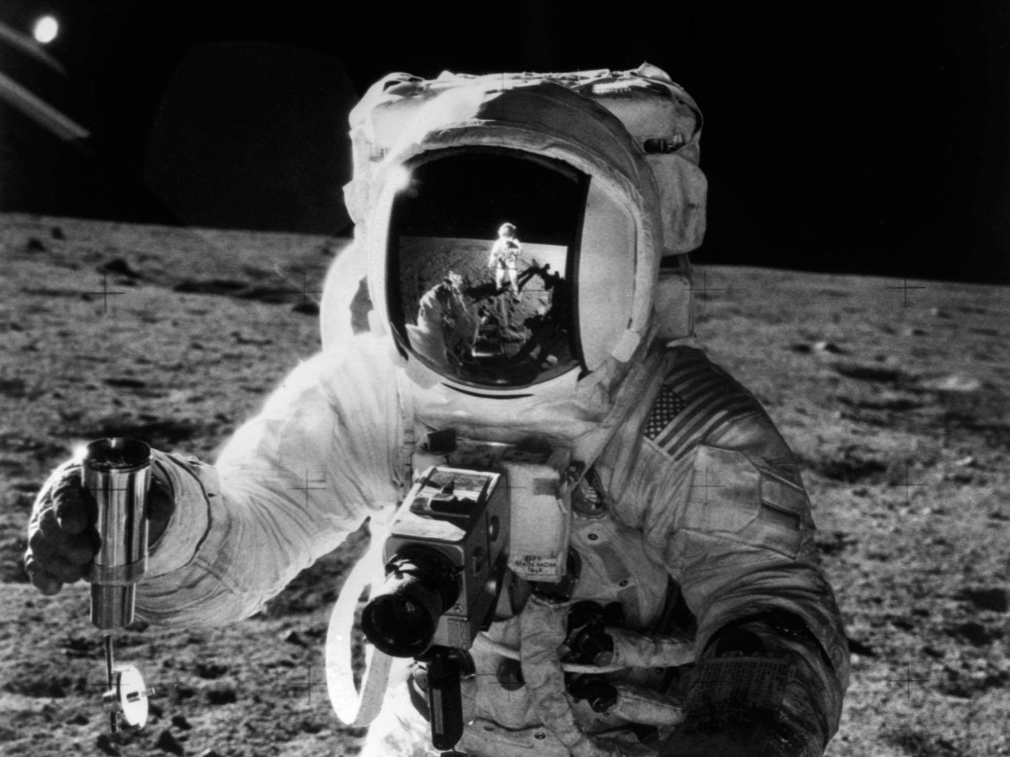 One of the astronauts of the Apollo 12 space mission conducting experiment on the moon's surface