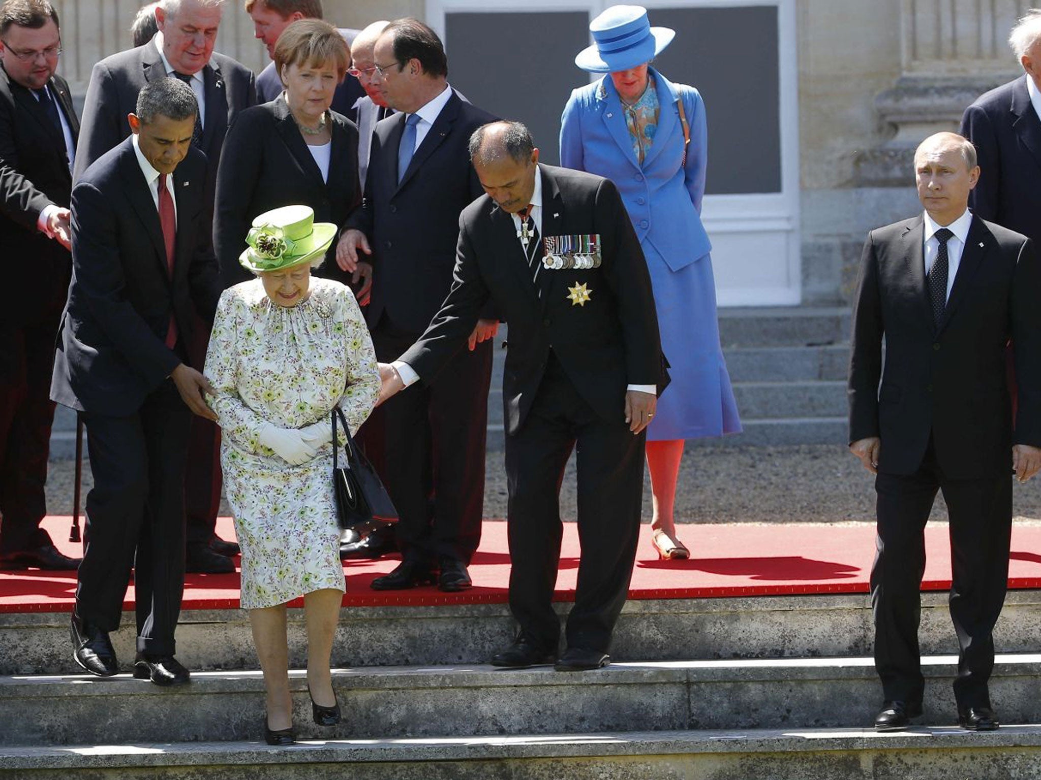 Russian President Vladimir Putin stands at right as U.S. President Barack Obama, left, and New Zealand's Governor-General Jerry Mateparae guide Britain's Queen Elizabeth II to her position for a group photo, with French President Francois Hollande, in the