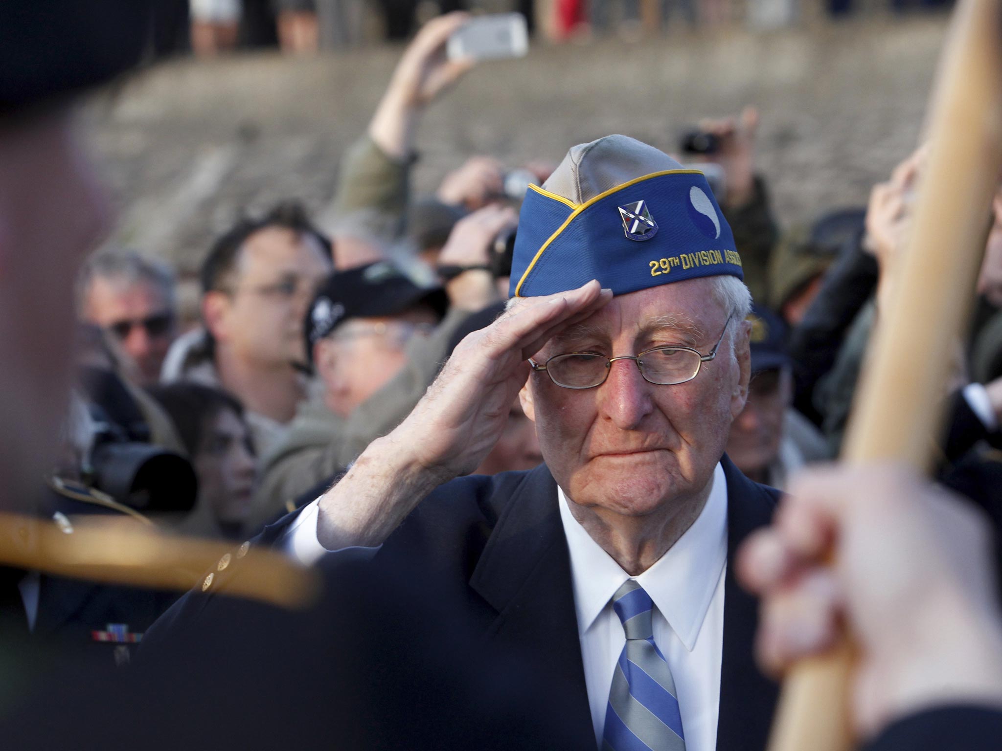 Veteran Morley Piper, 90, salutes during a D-Day commemoration, on Omaha Beach in Vierville sur Mer, western France