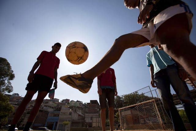 Nearly time for kick off: Young Brazil fans playing football on the outskirts of Sao Paulo