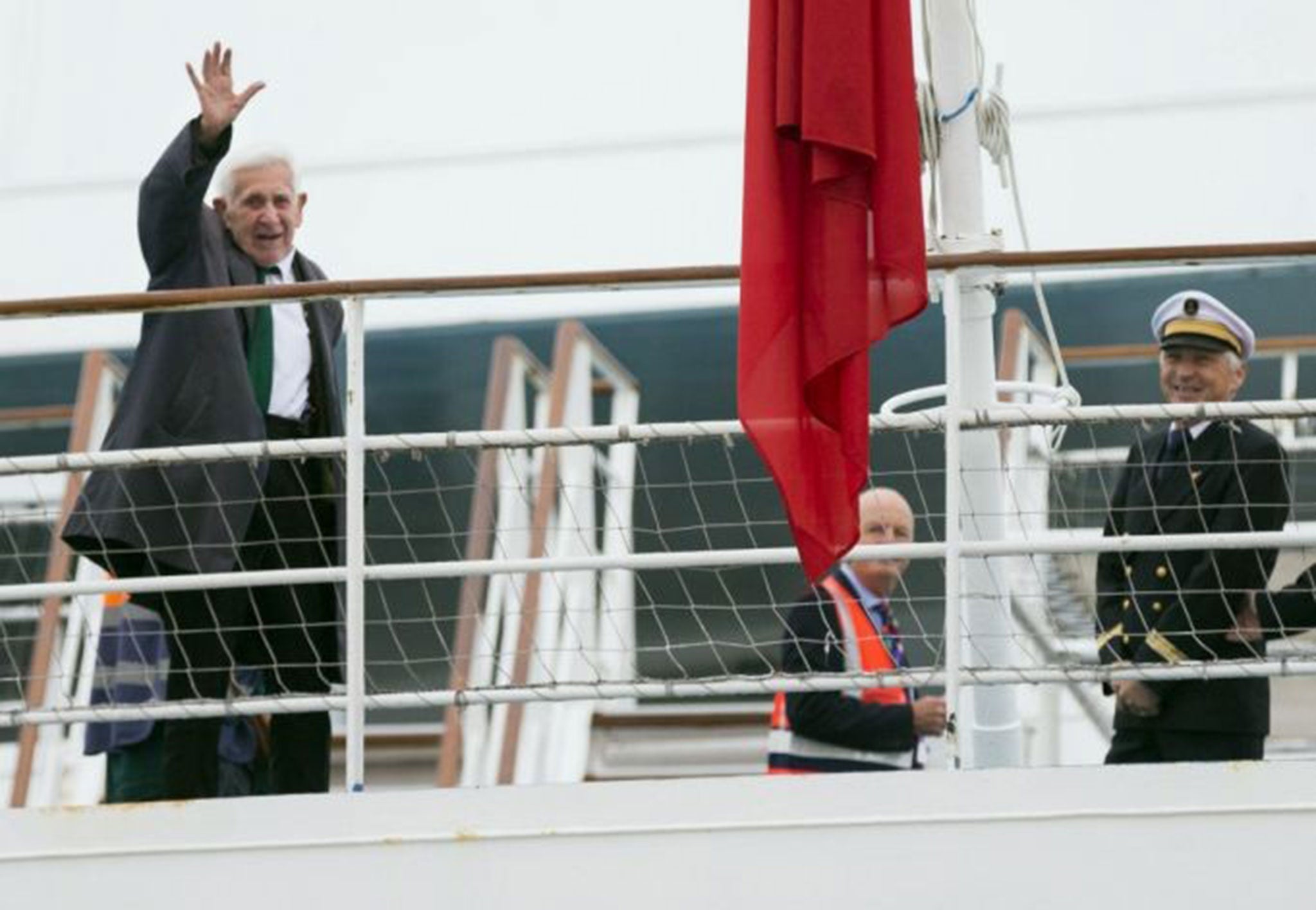 Brittany Ferries' skipper, Captain Olivier Macoin, right, smiles as war veteran Bernard Jordan gestures, from the deck of the ferry Normandie at Portsmouth Harbour