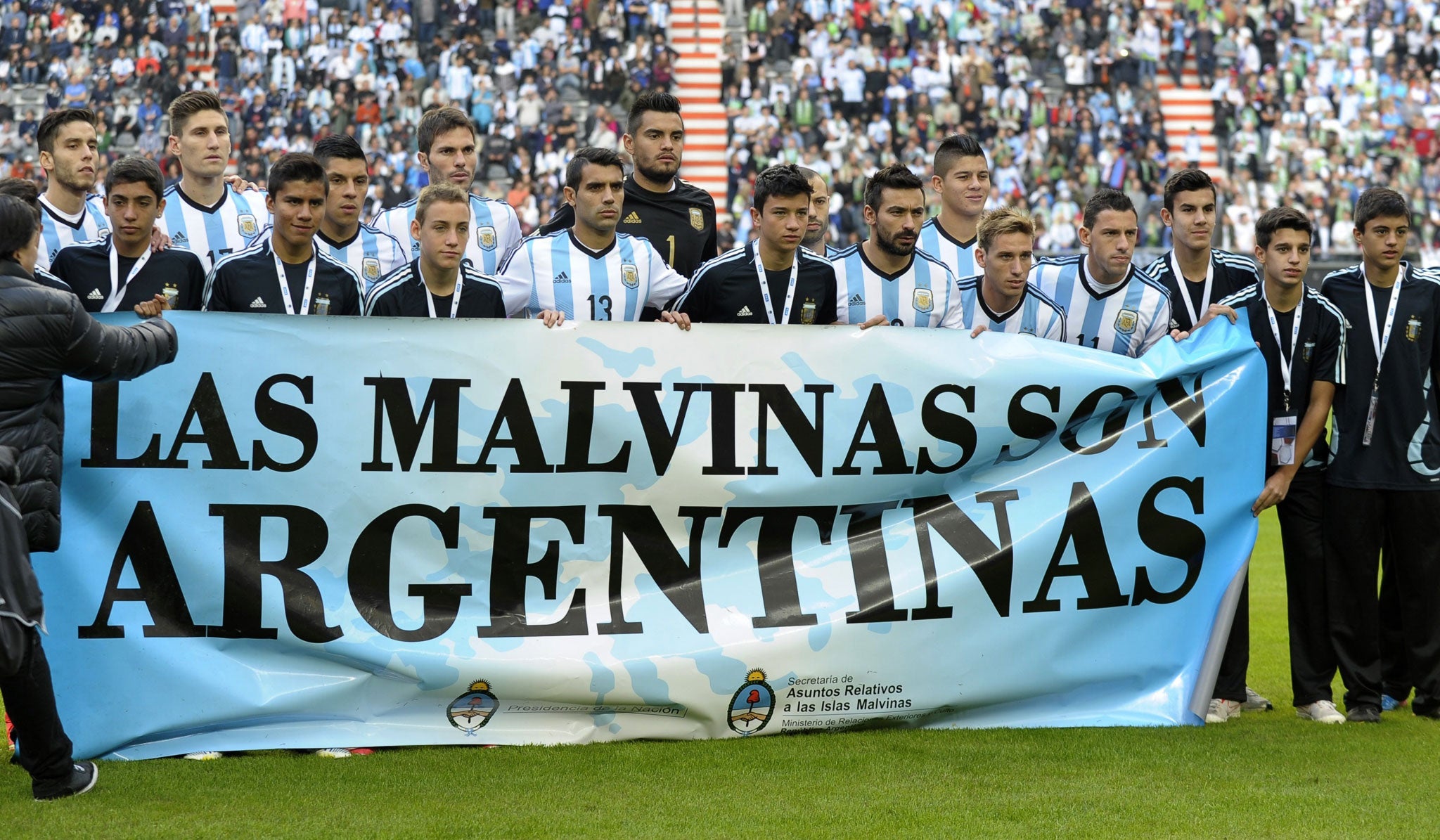 Argentina's footballers pose for photographers holding a banner reading "The Malvinas are Argentinian" before a friendly against Slovenia at La Plata stadium in Buenos Aires