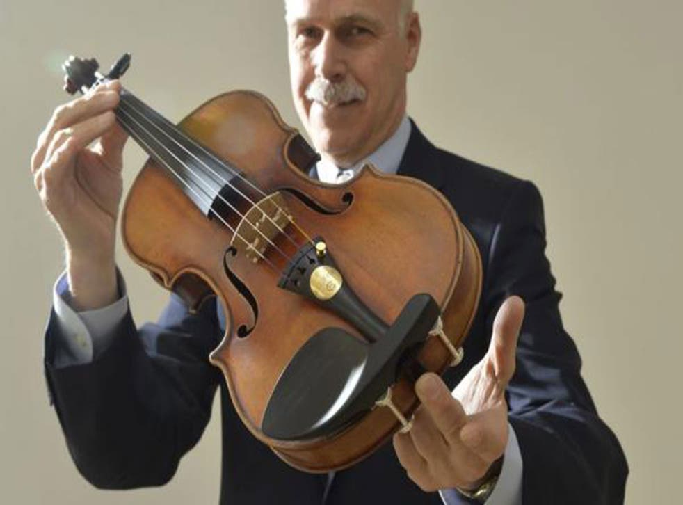 Kerry Keane Christies Musical Instruments specialist poses for a photograph with the Kreutzer Stradivarius violin in London on 9 May 2014