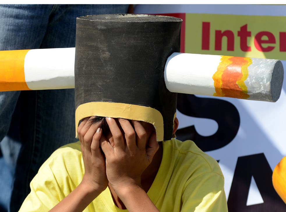 An anti-smoking protester wears a head piece at a rally at the entrance gate of the World Trade Center in Manila on March 20, 2013 where the world's biggest tobacco trade show was being held.