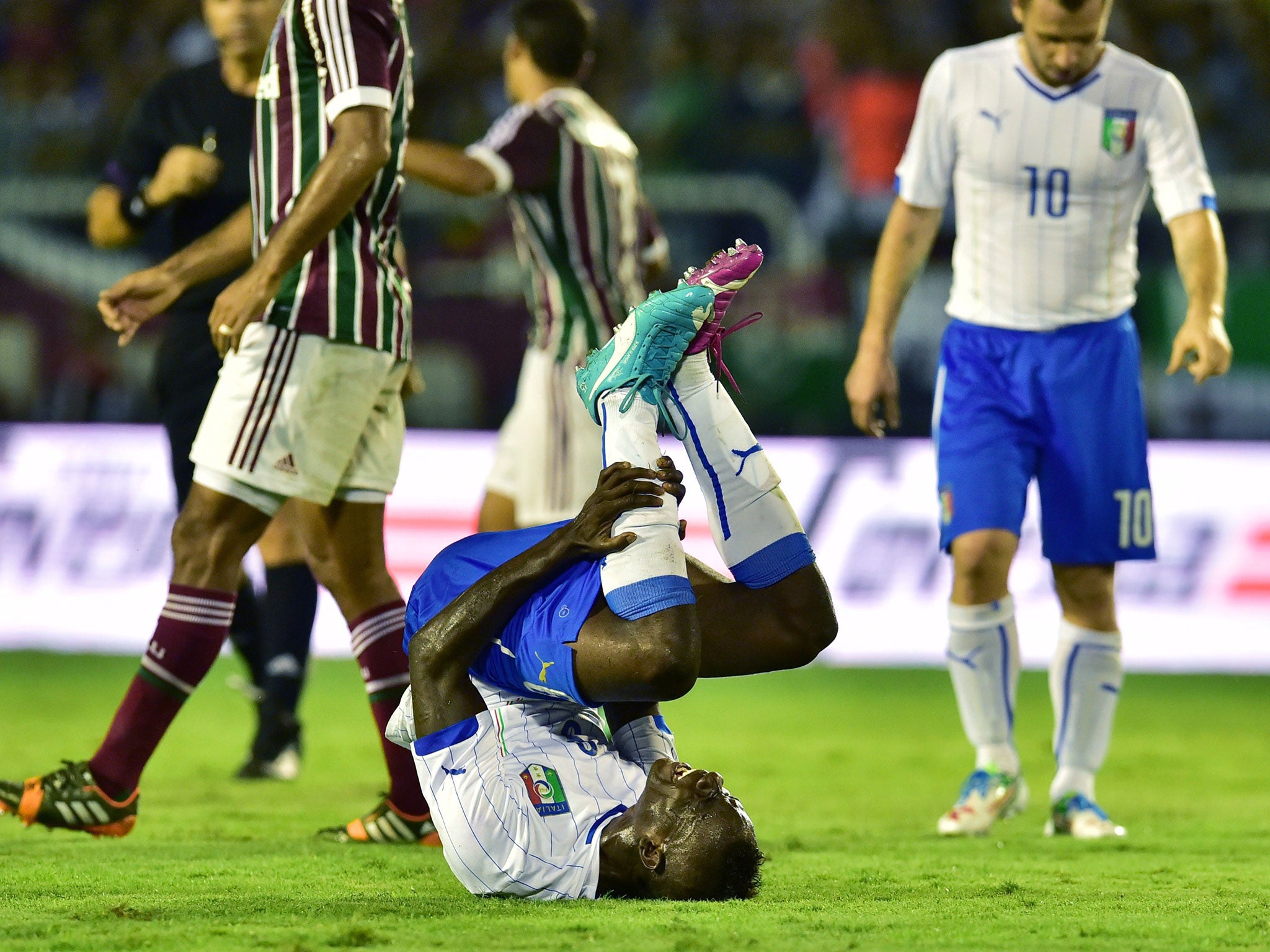 Italy's forward Mario Balotelli lies on the pitch after being injured during a friendly football match between Fluminense and Italy at the Raulino de Oliveira Stadium in Volta Redonda