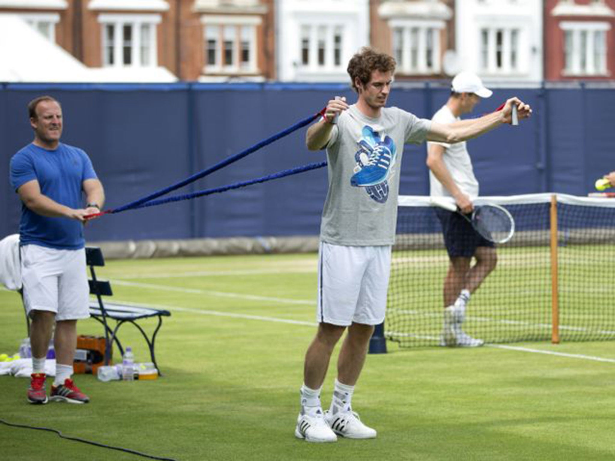 Andy Murray warms up for the grass-court season with some stretches at Queen’s yesterday