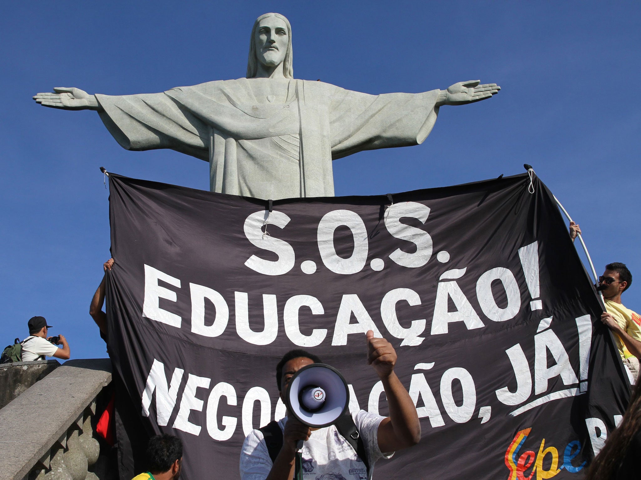 Brazilian protesters take over the Cristo Redentor statue viewing platform in Corcovado, Rio de Janeiro. The protestors ask for improved funding for public education instead of expenditures in athletic events