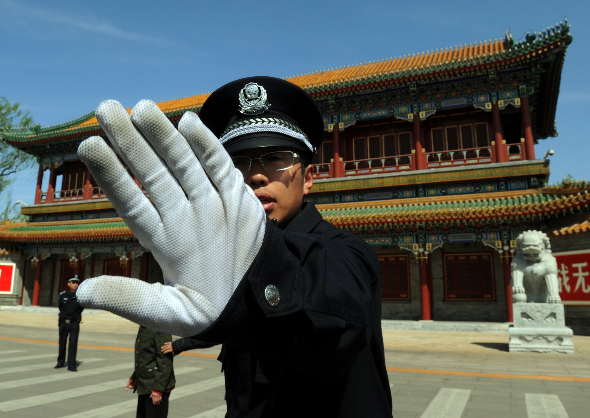 A Chinese policeman blocks photos being taken outside Zhongnanhai which serves as the central headquarters for the Communist Party of China