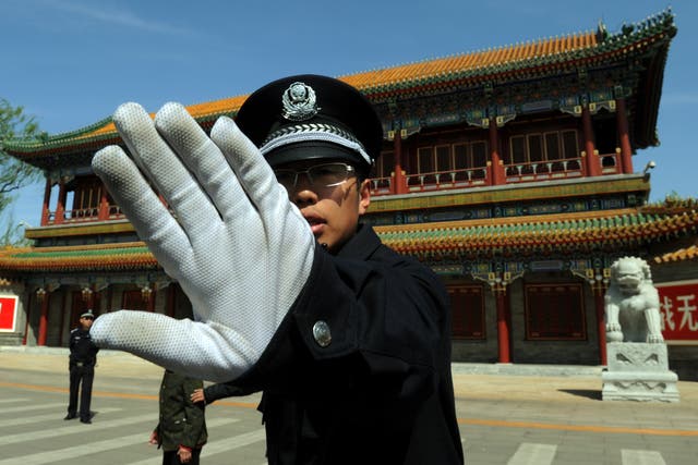 A Chinese policeman blocks photos being taken outside Zhongnanhai which serves as the central headquarters for the Communist Party of China
