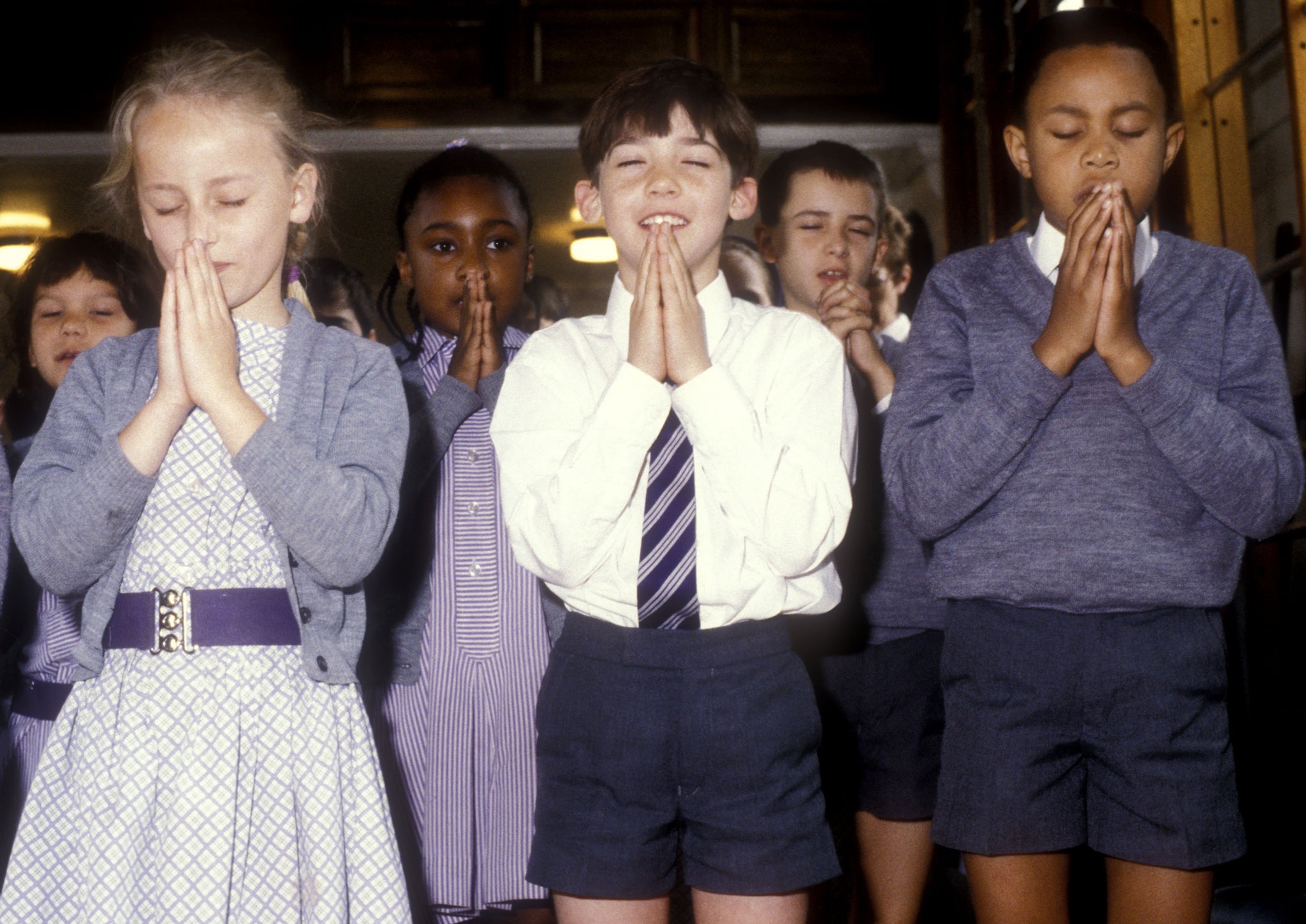Children pray at a school in South London