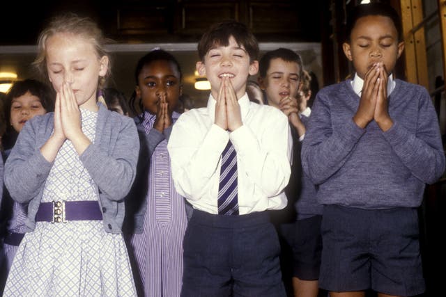 Children pray at a school in South London