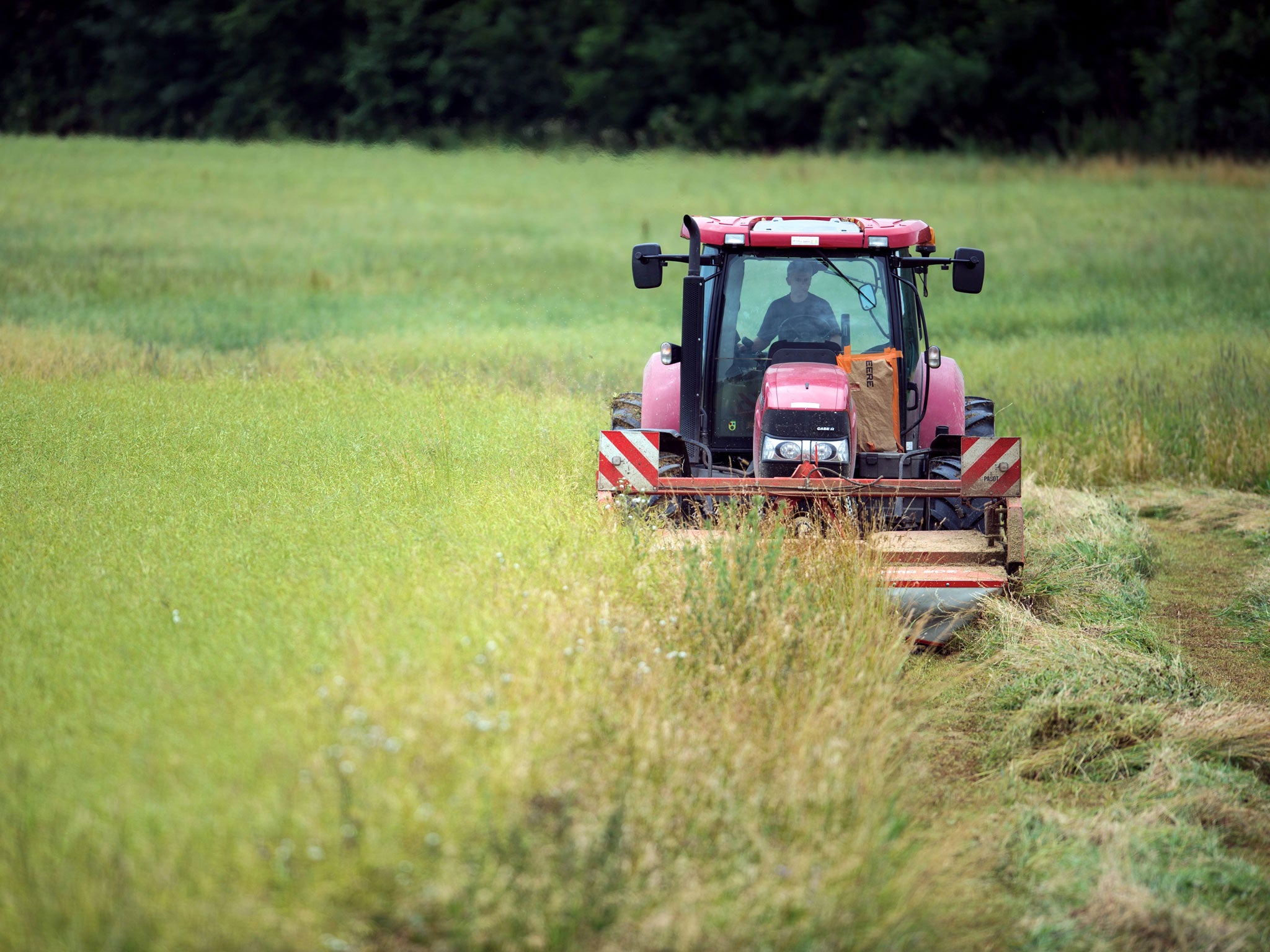 A farmer drives a tractor, unrelated to the incident involving Clouse, on a field in France.