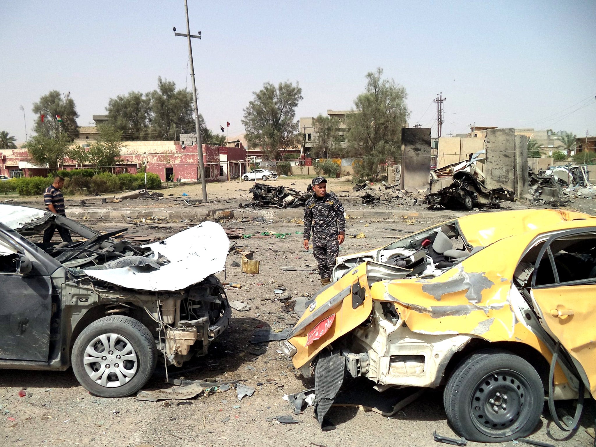 The scene of a car bomb attack in Tuz Khurmato, between Mosul and Baghdad, on Monday. At least 20 people died