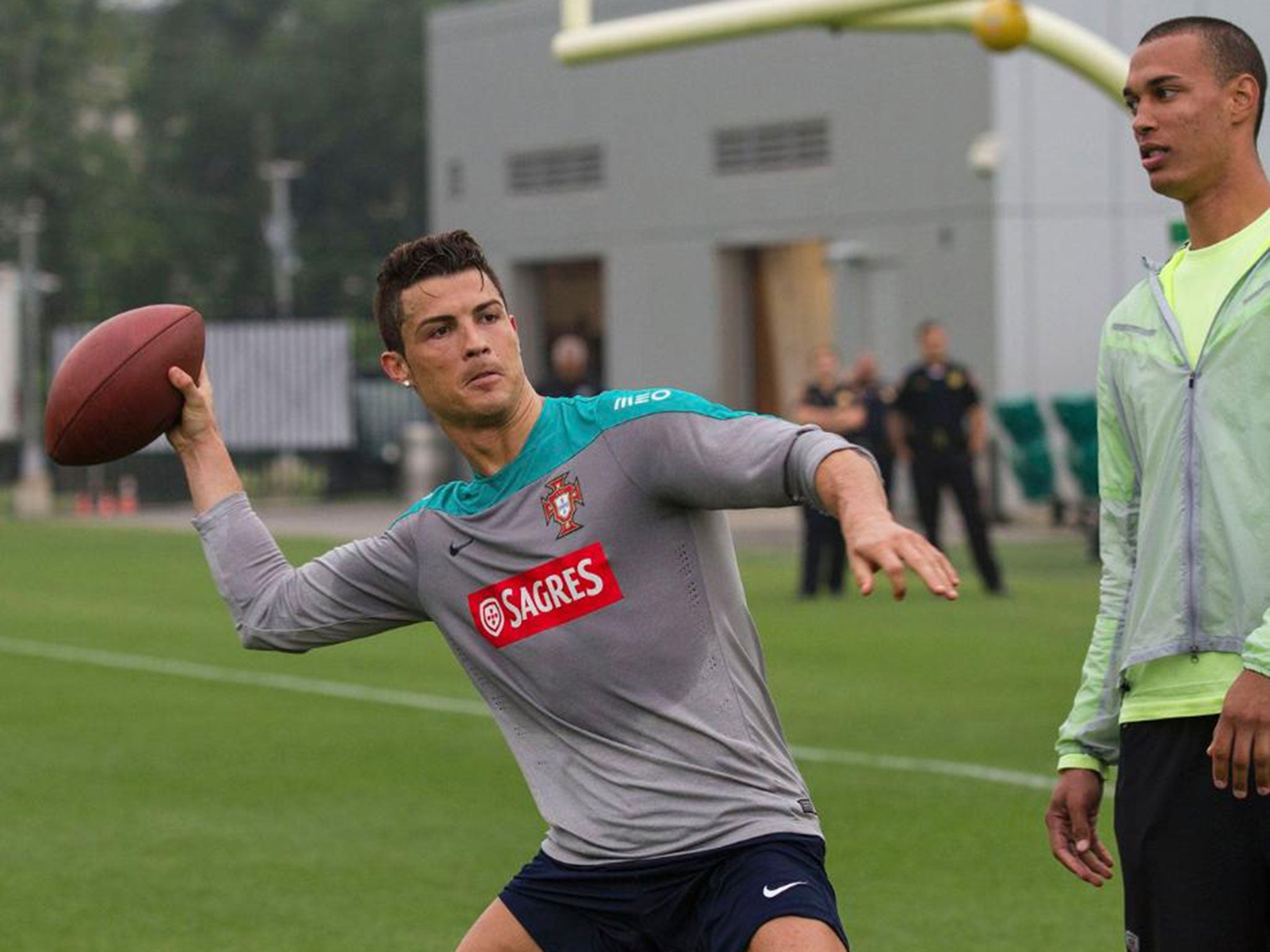 Cristiano Ronaldo throws an American football at the New York Jets training facility