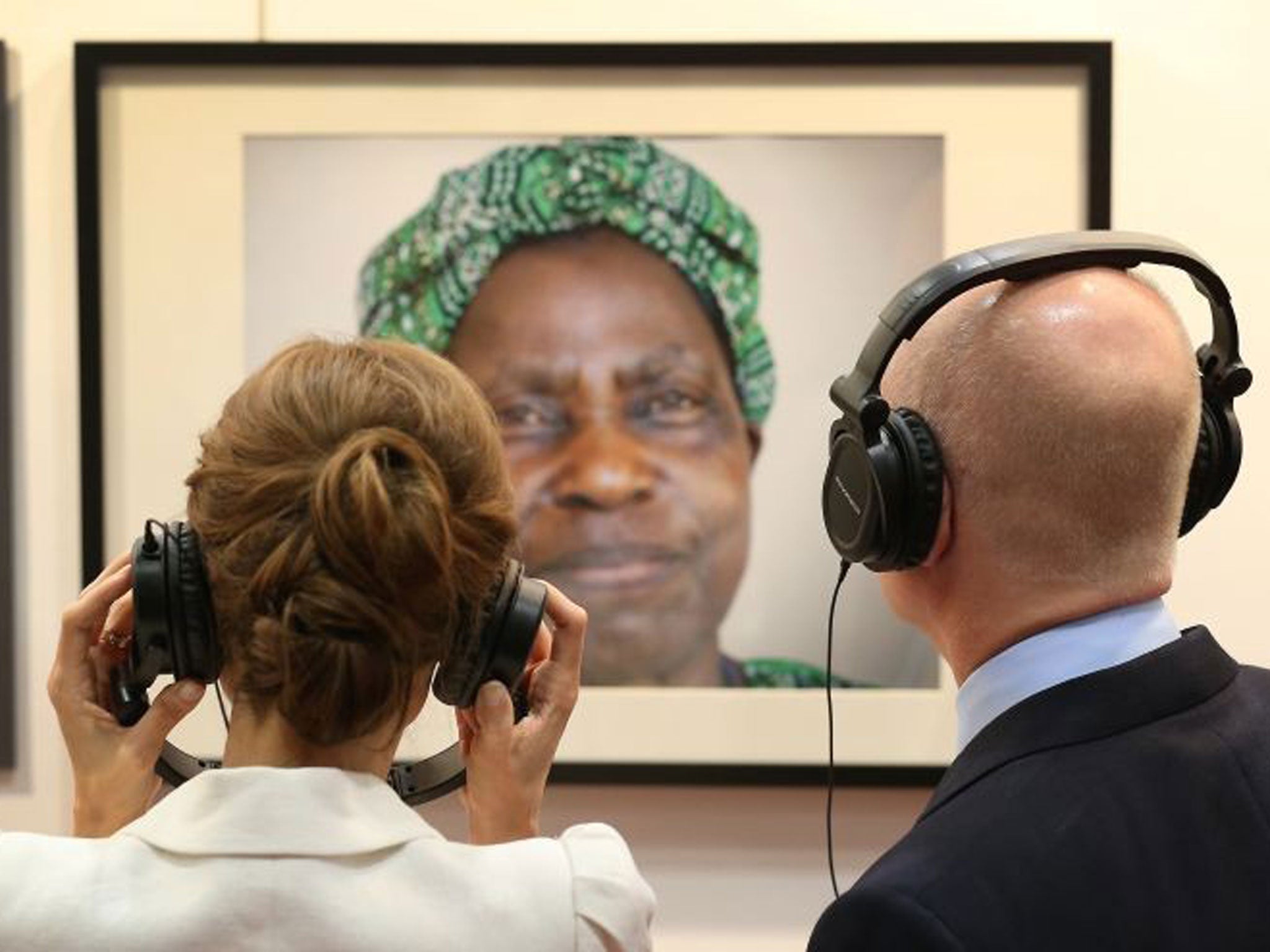 Angelina Jolie stands with British Foreign Secretary William Hague as they listen to an audio recording from a peace worker