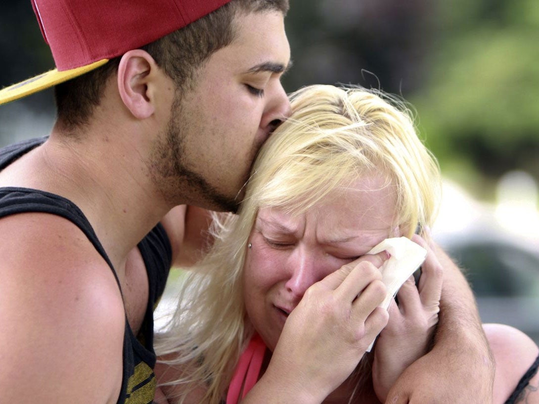 Two people comfort each other as they await word about the safety of students after a shooting at Reynolds High School, Tuesday, June 10, 2014, in Troutdale, Ore
