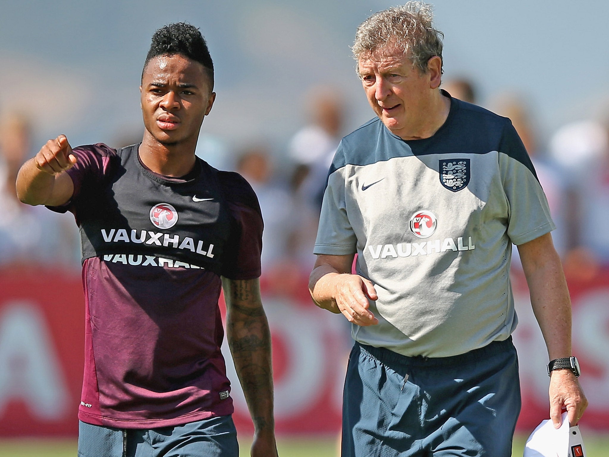 Raheem Sterling talks with manager Roy Hodgson during an England training session