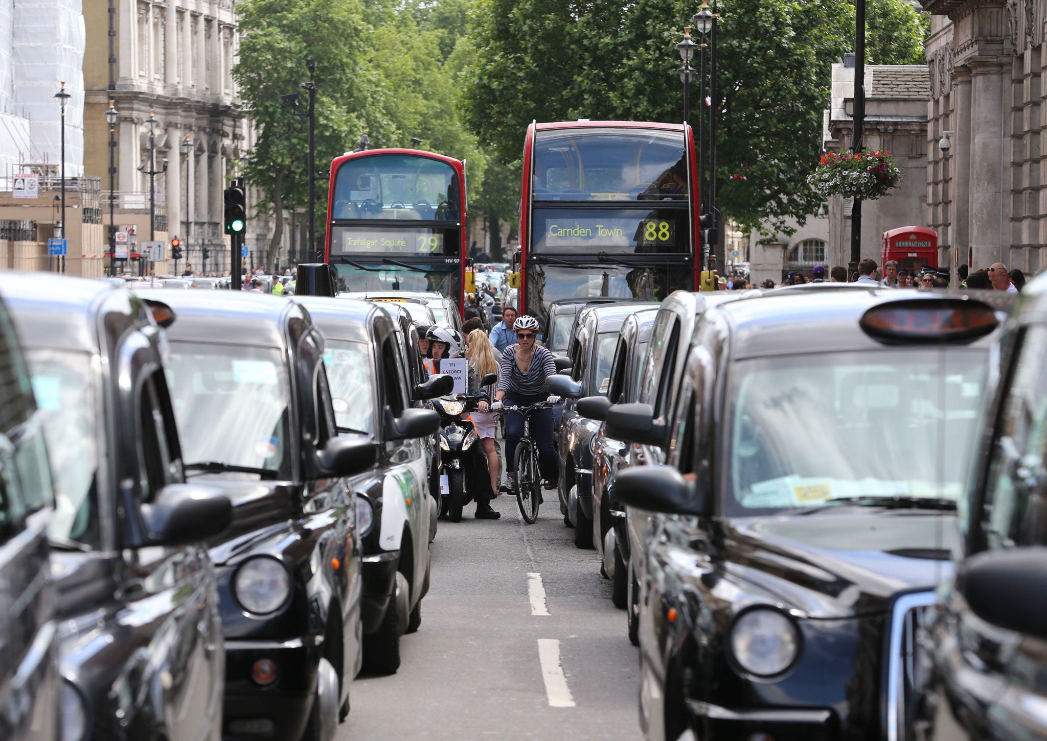 Black cab and licensed taxi drivers protest at Trafalgar Square, London over the introduction of phone app Uber which allows customers to book and track vehicles