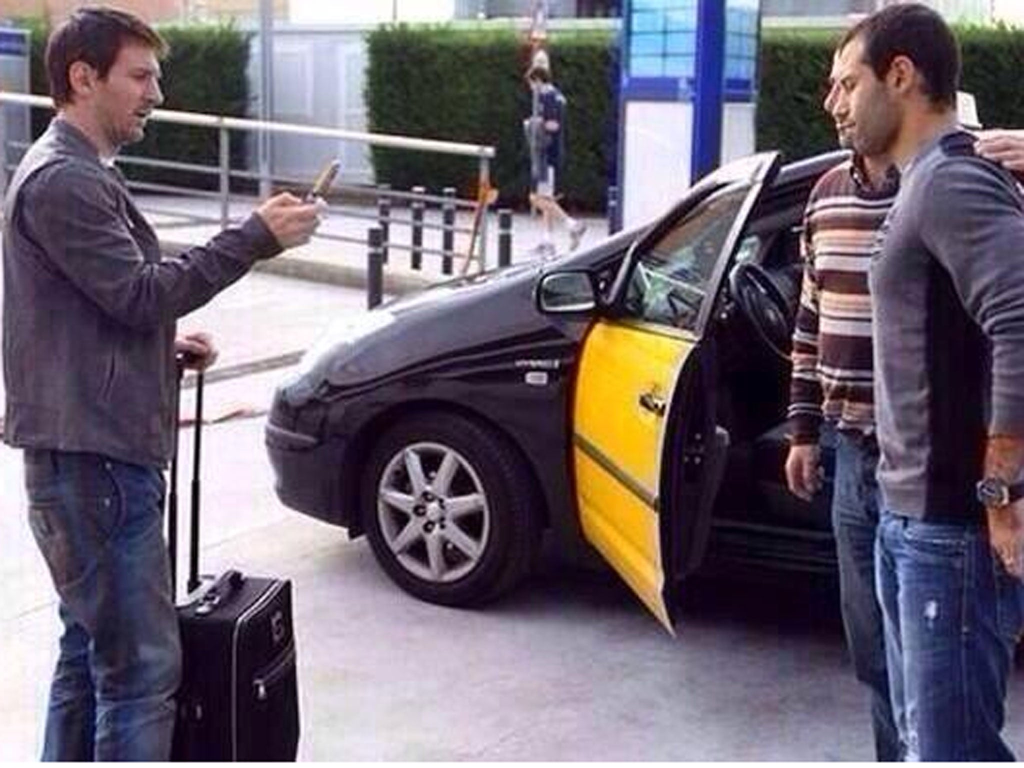 Lionel Messi takes a picture for Javier Mascherano and a fan