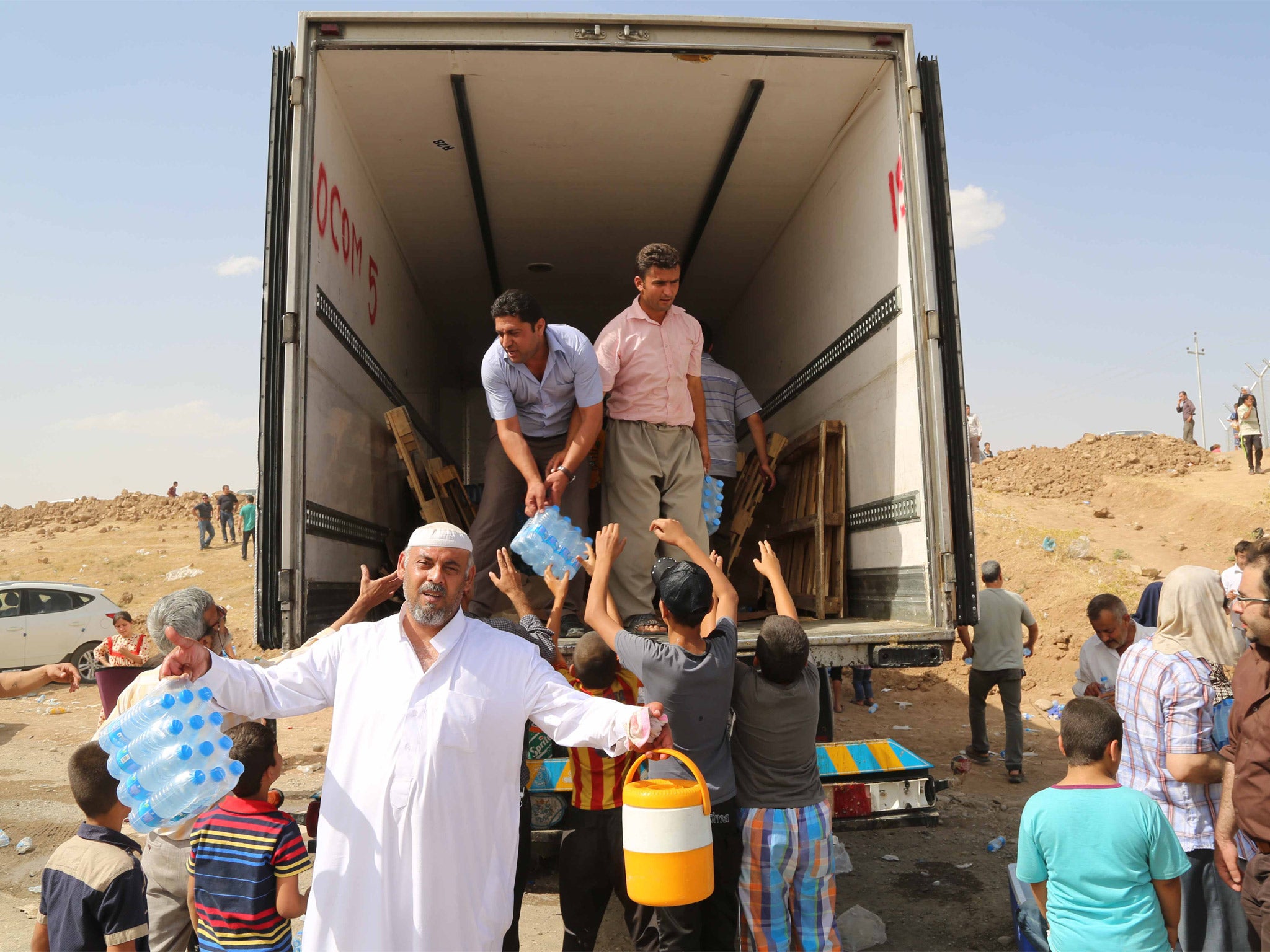 Families load their belongings on to a lorry as they flee Mosul