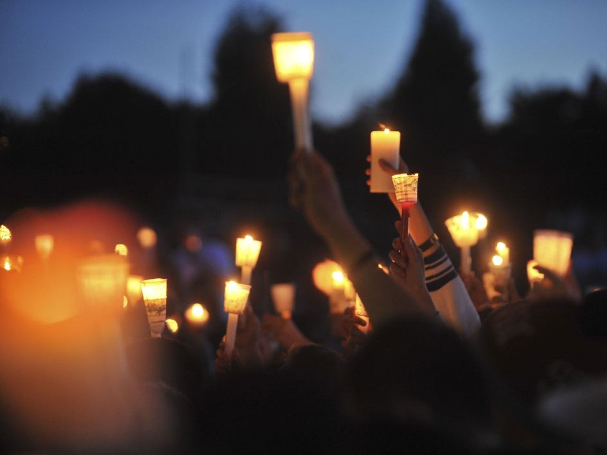 People participate in a candlelight vigil for Emilio Hoffman