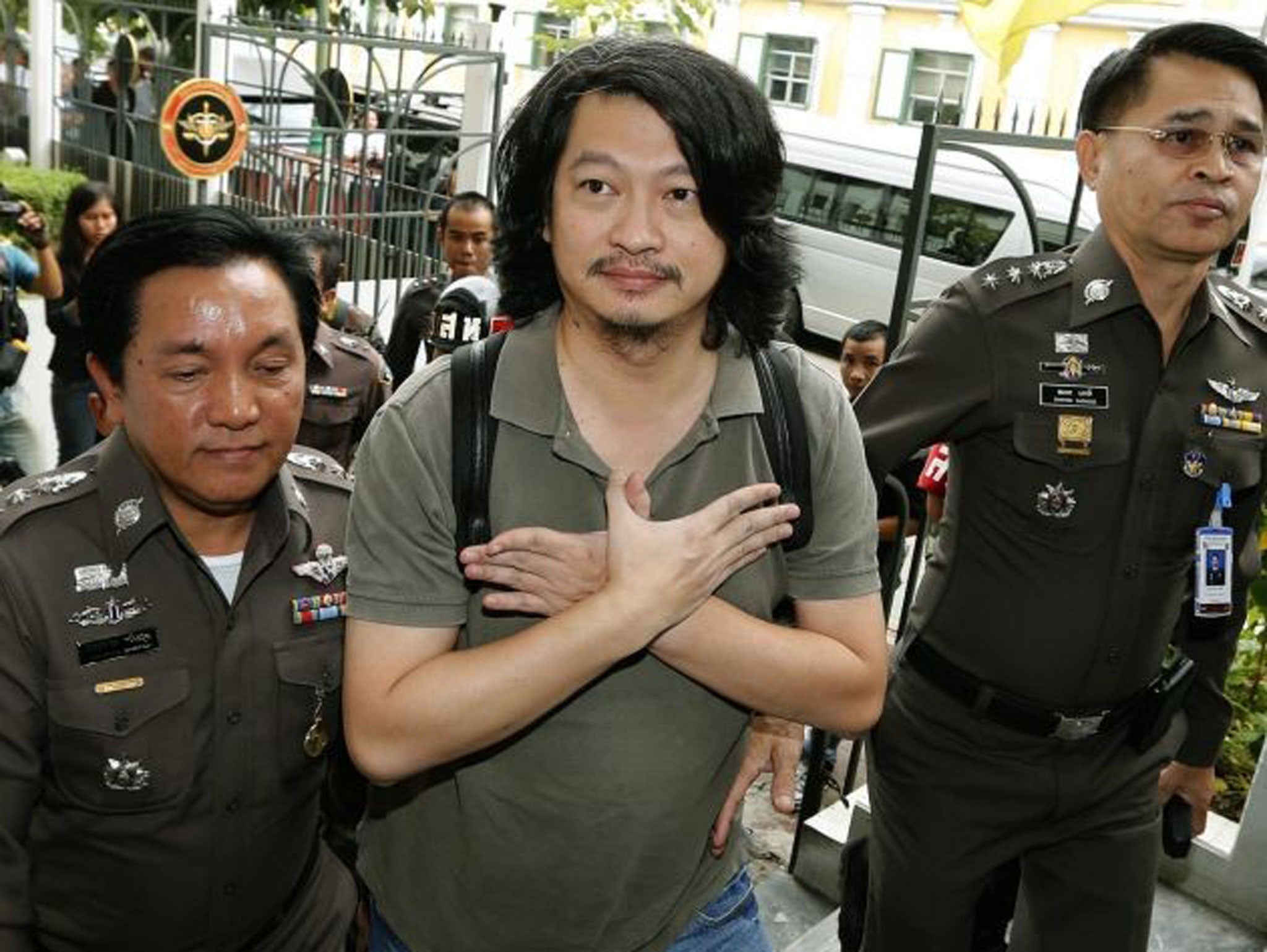 Sombat Boonngamanong gestures as he arrives at the Martial Court in Bangkok