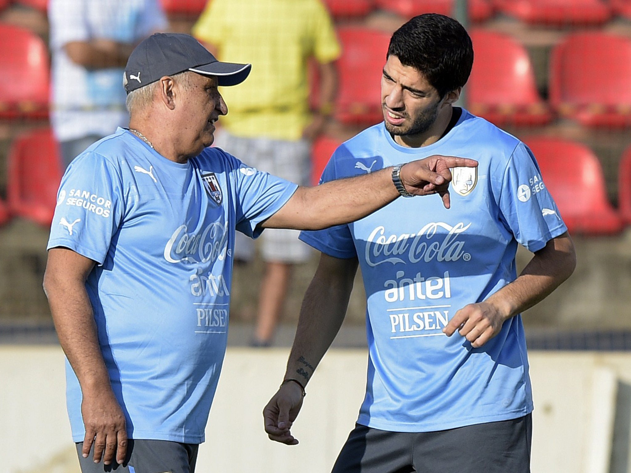 Luis Suarez listens to Uruguay medical staff member Walter Ferreira