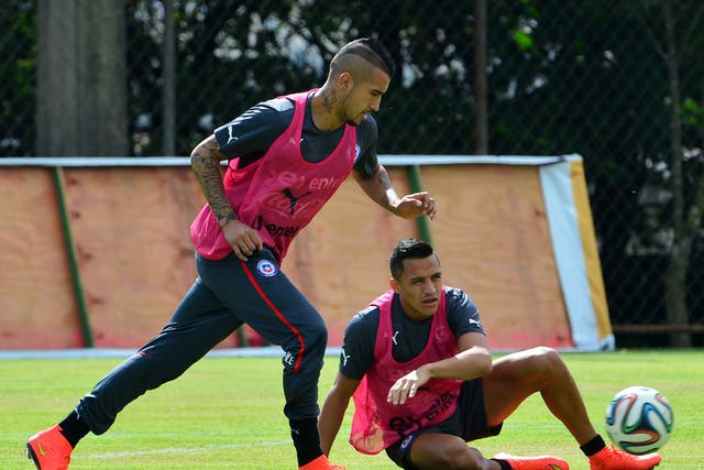 Chile's national football team midfielder Arturo Vidal (L) controls the ball as his teammate forward Alexis Sanchez (R) watches on during a training session