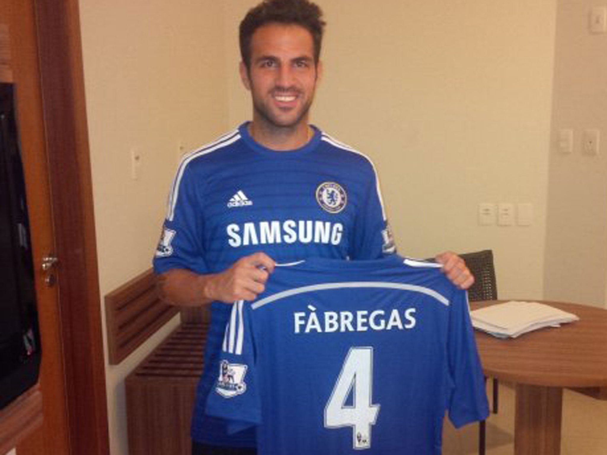 Cesc Fabregas poses with his Chelsea shirt after signing