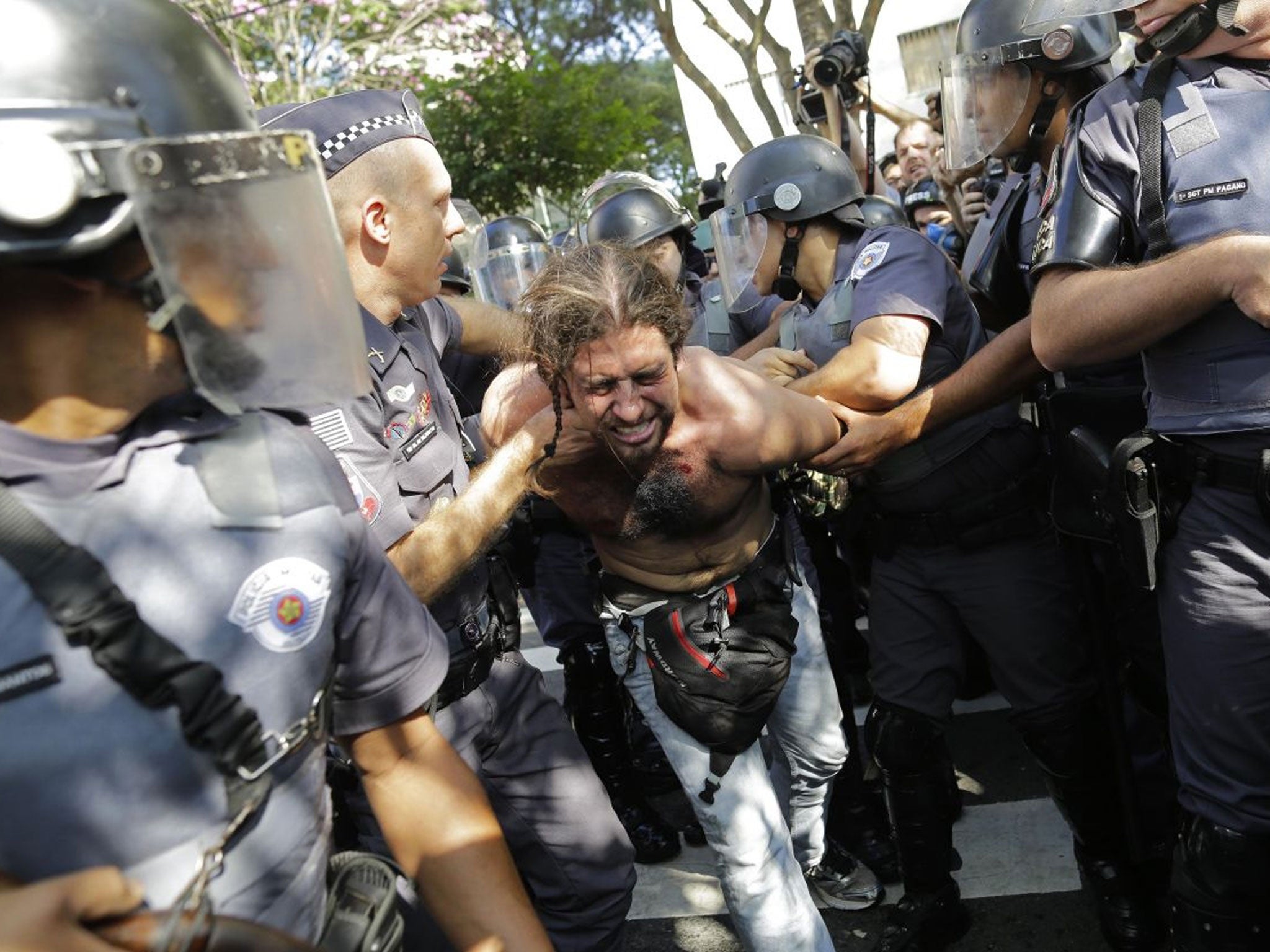 A protester is detained by police during a demonstration by people demanding better public services and against the money spent on the World Cup soccer tournament in Sao Paulo, Brazil, Thursday, June 12, 2014. Brazilian police clashed with anti-World Cup protesters trying to block part of the main highway leading to the stadium that hosts the opening match of the tournament. (AP Photo/Nelson Antoine)