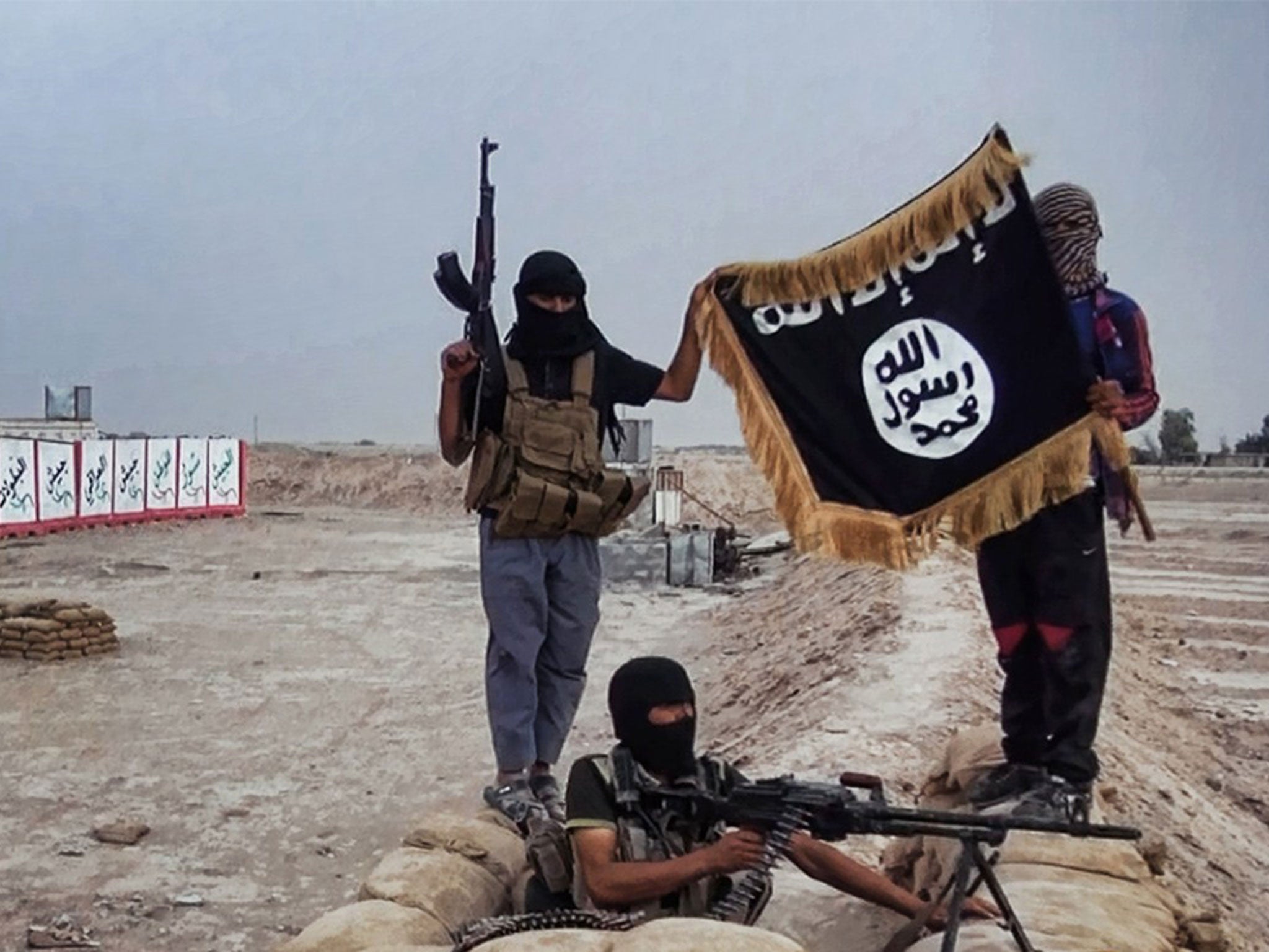 Isis rebels show their flag after seizing an army post