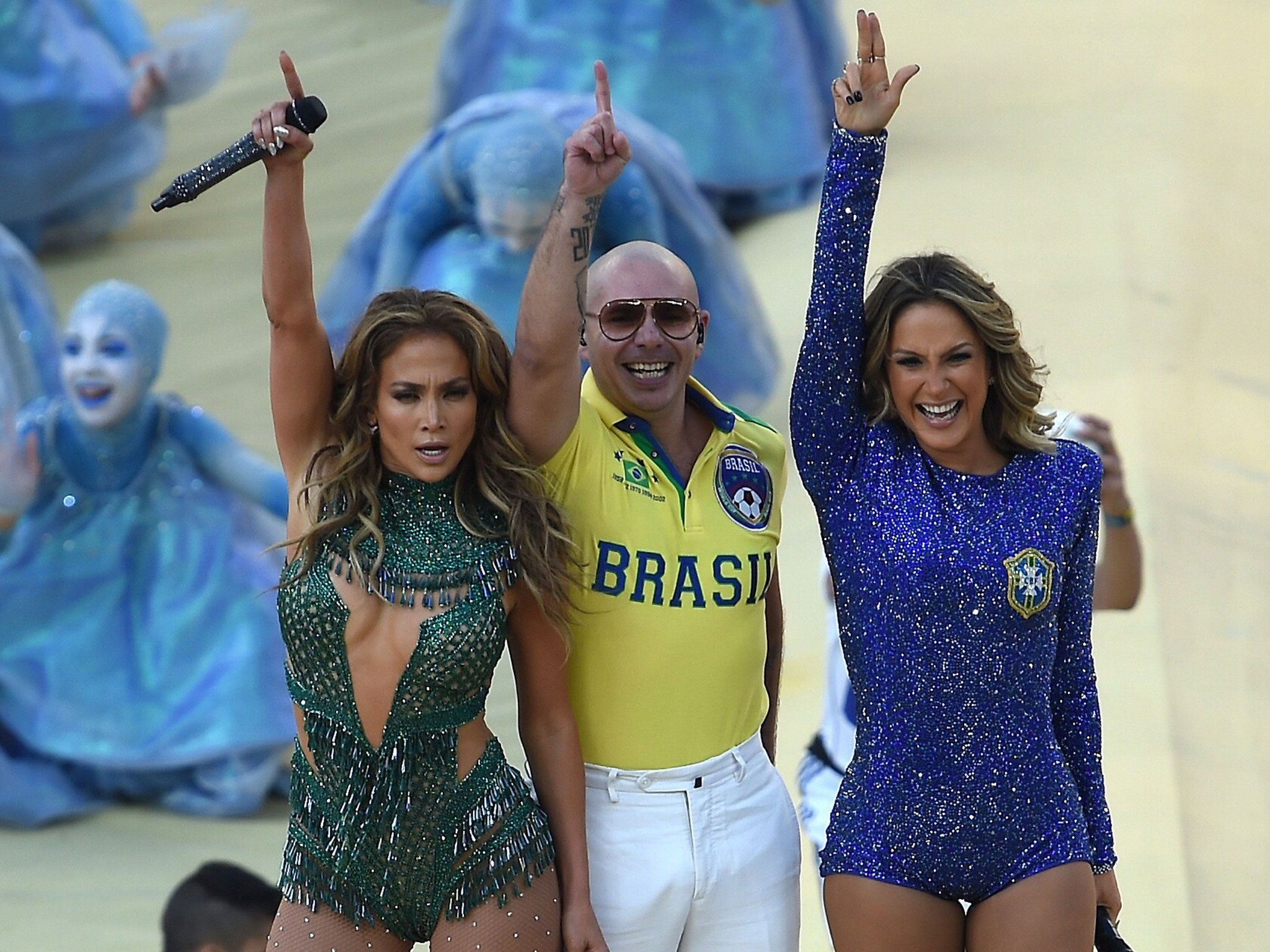 US rapper Pitbull (C) Brazilian pop singer Claudia Leitte (R) and US singer Jennifer Lopez (L) salute the audience as they take part in the opening ceremony of the 2014 FIFA World Cup