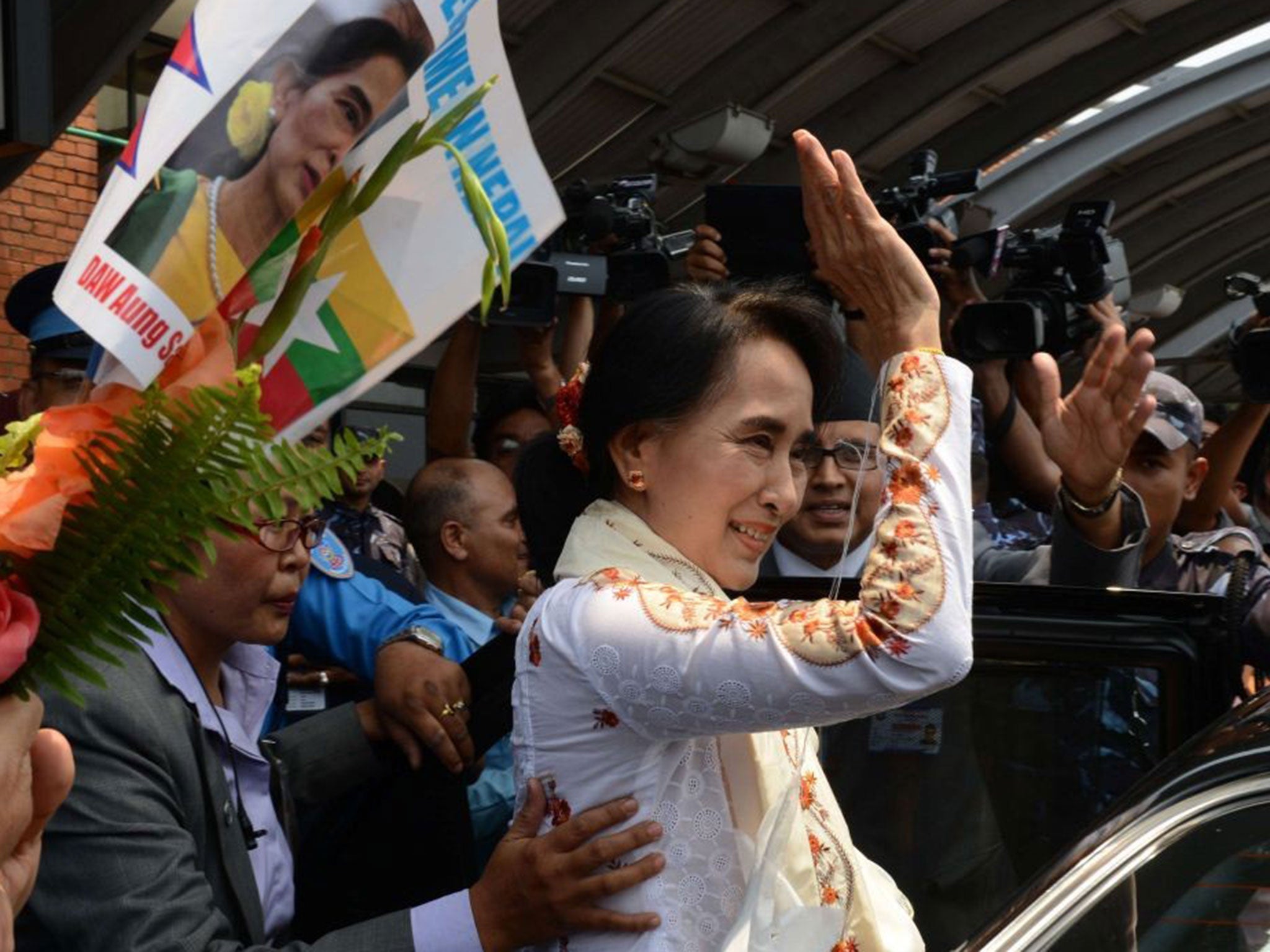 Aung San Suu Kyi gestures on her arrival at Tribhuvan International airport in Kathmandu on 13 June 13 2014 for a four-day official visit to Nepal