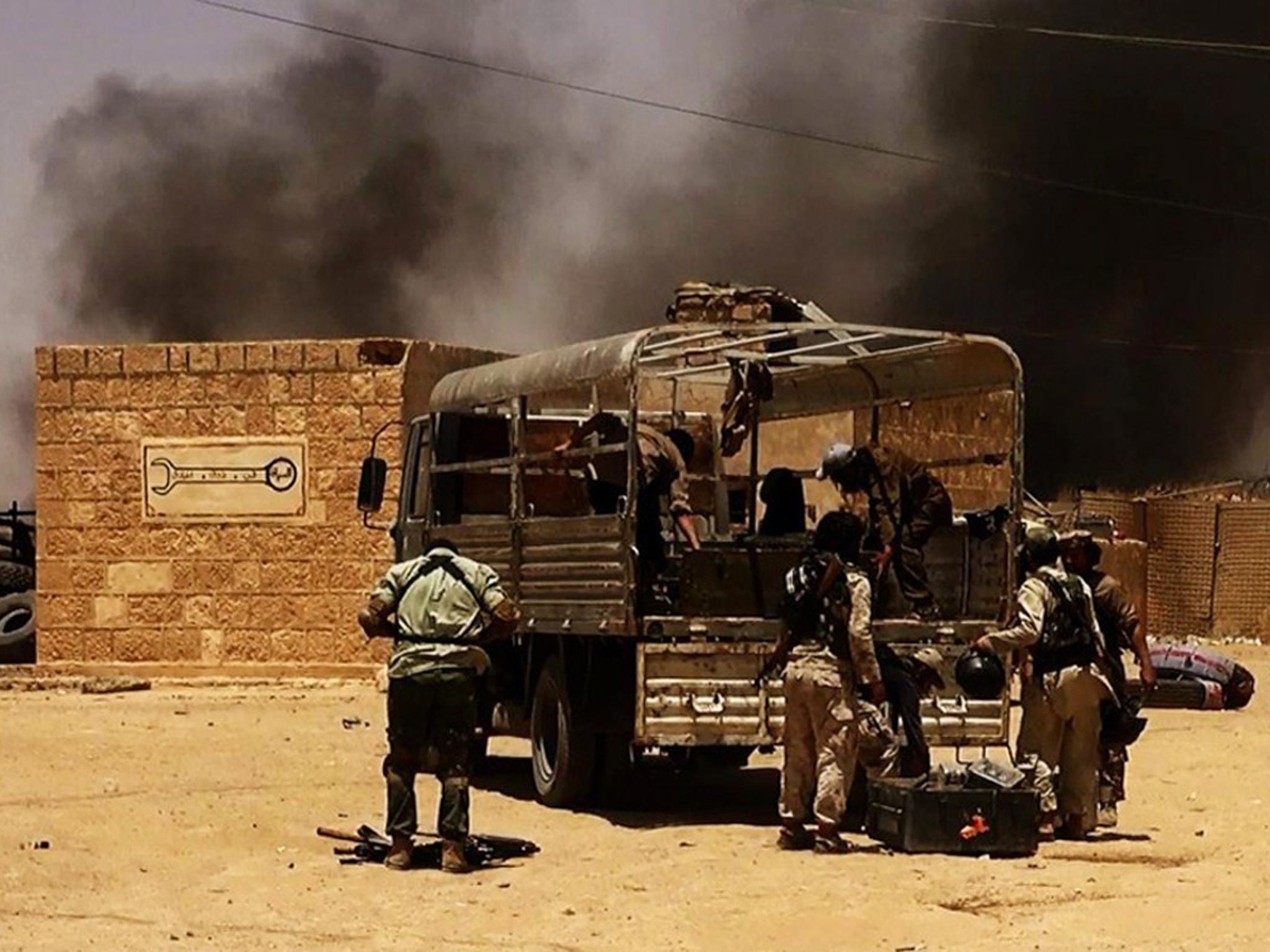 Isis militants take position at a checkpoint on the Syrian-Iraqi border