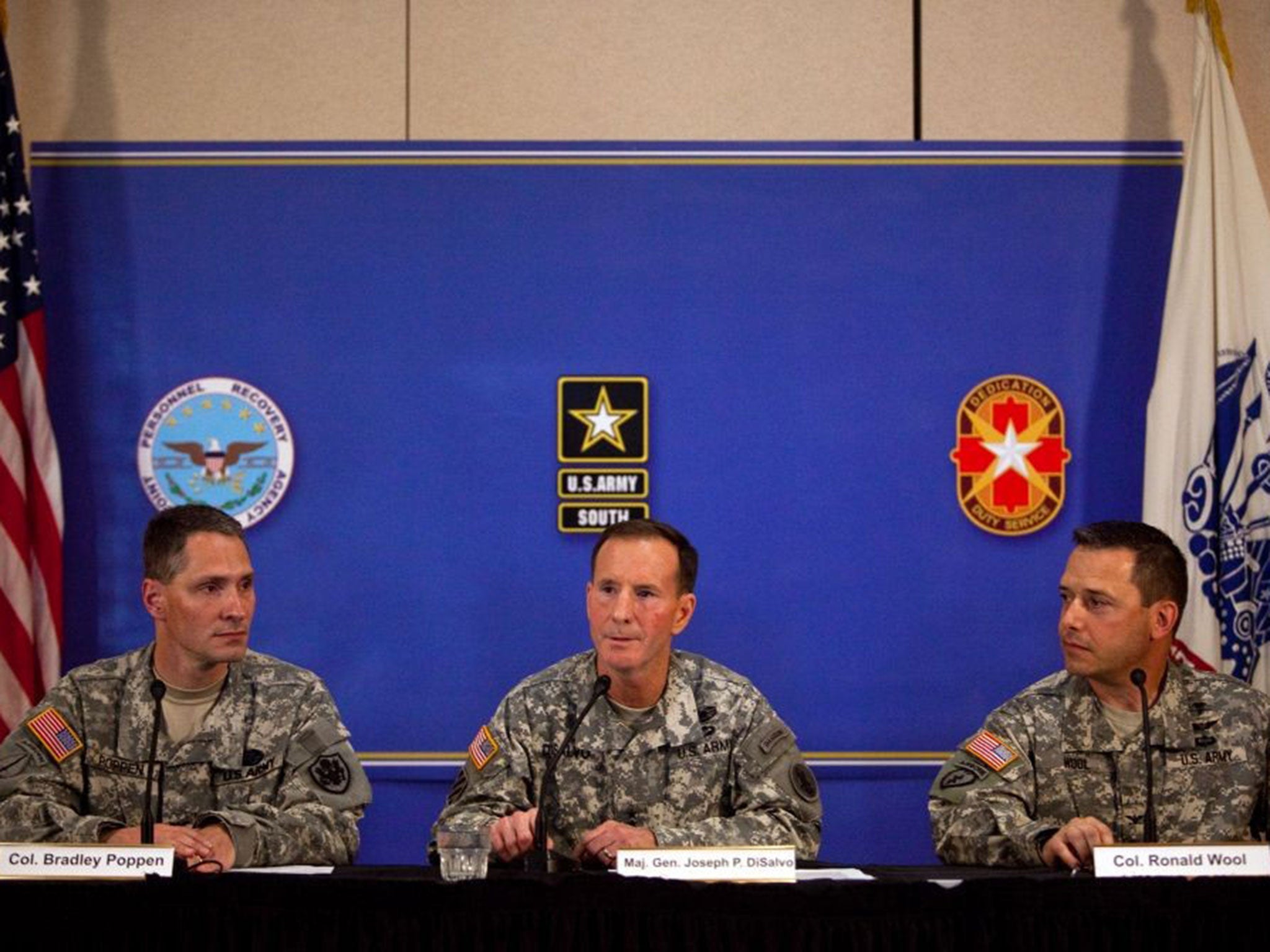 Colonel Bradley J. Kamrowski, Ph.D., Major General Joseph P. DiSalvo, and Colonel Ronald N. Wool deliver a press conference at the Fort Sam Houston Golf Course July 13, 2014 in San Antonio, Texas. They are reporting on Sgt. Bowe Bergdahl, his return to t