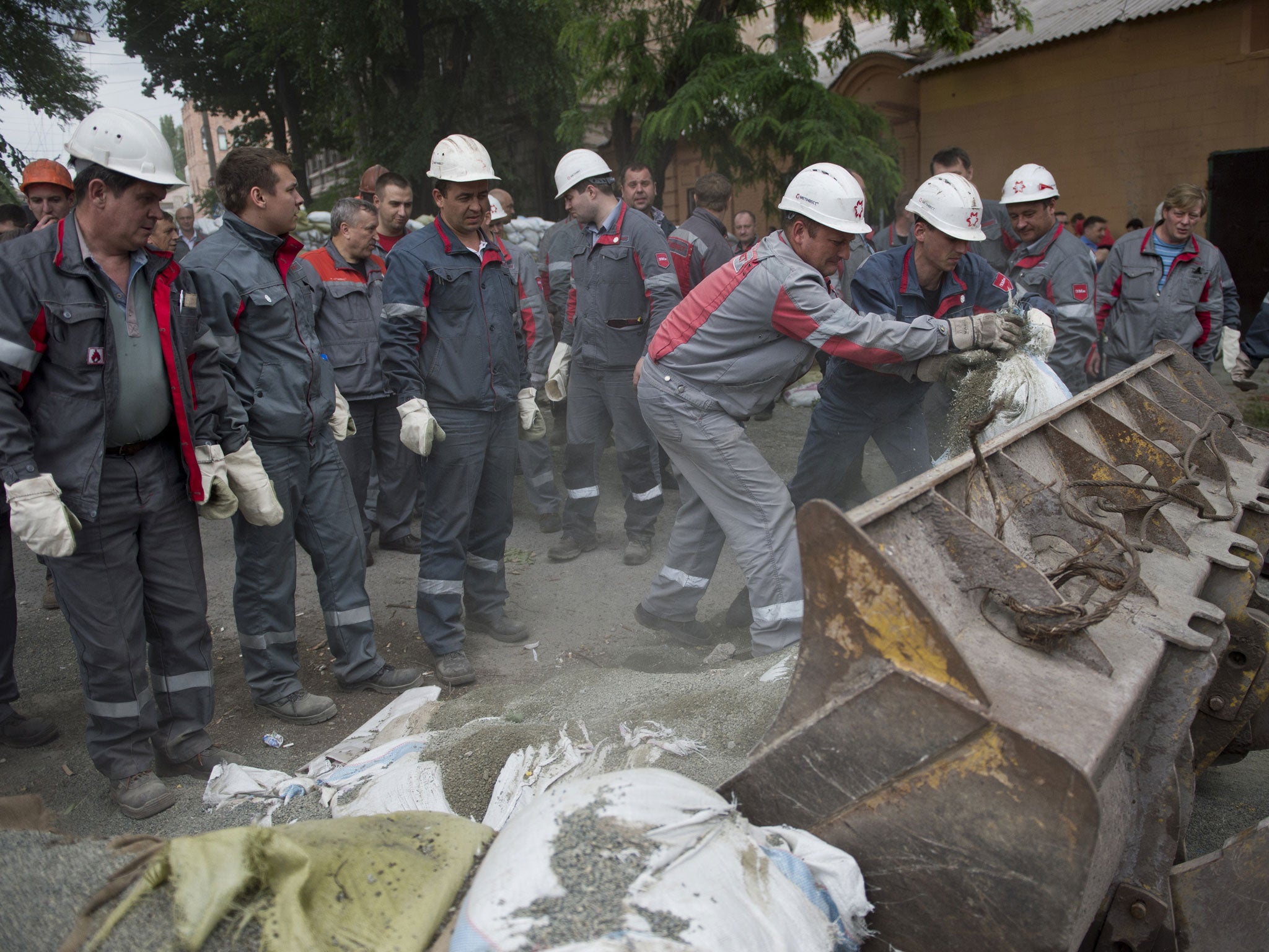 Workers remove the roadblocks once manned by insurgents