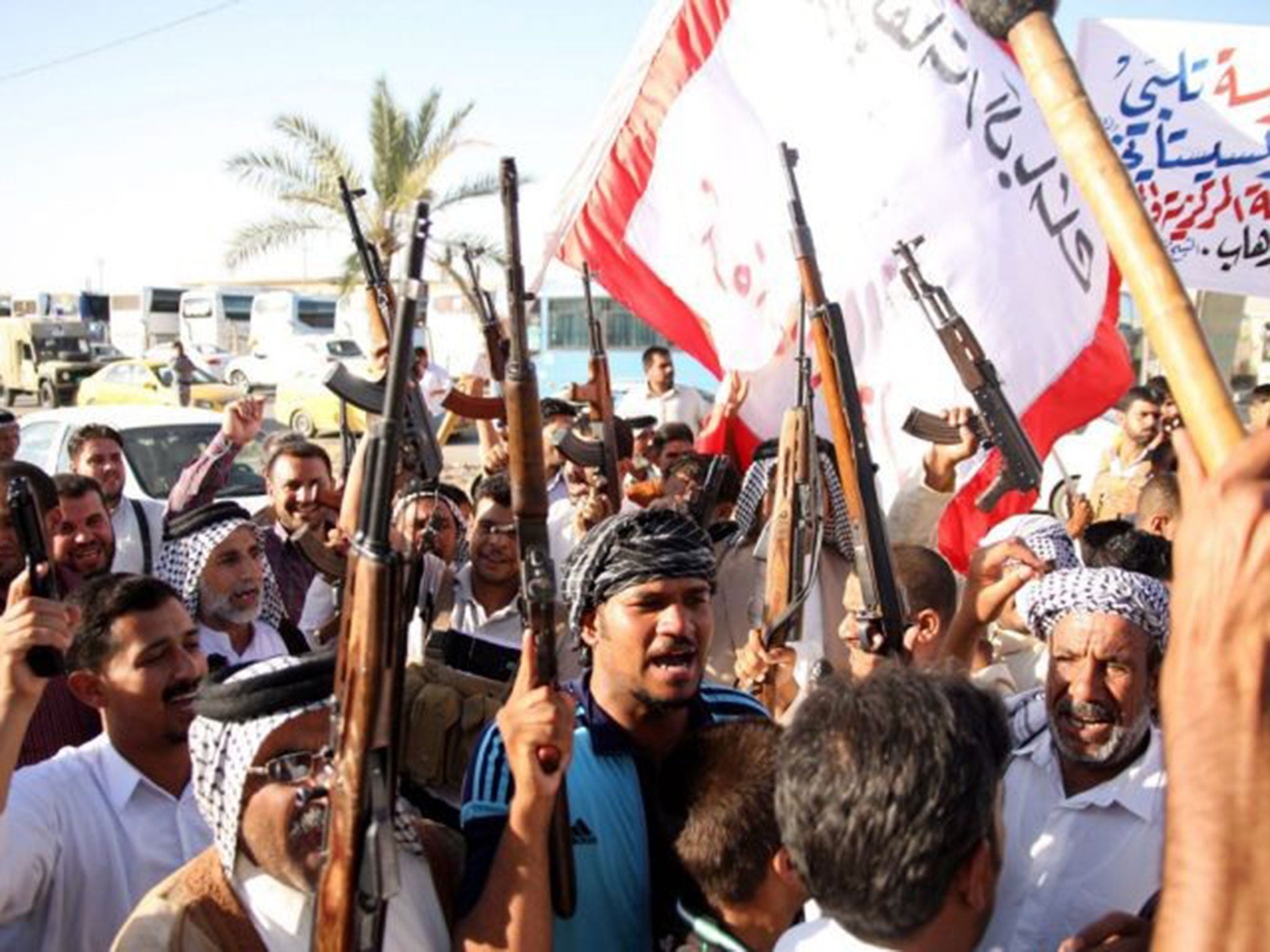 Iraqi volunteers carry their weapons and chant slogans in Karbala, southern Baghdad