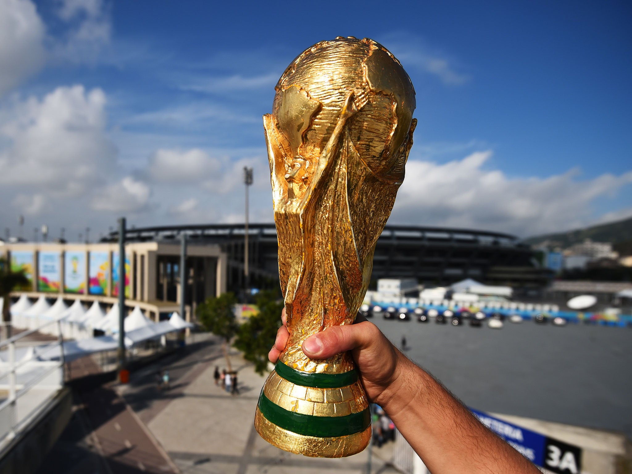 A fan holds a replica of the World Cup Trophy near the Maracana Stadium