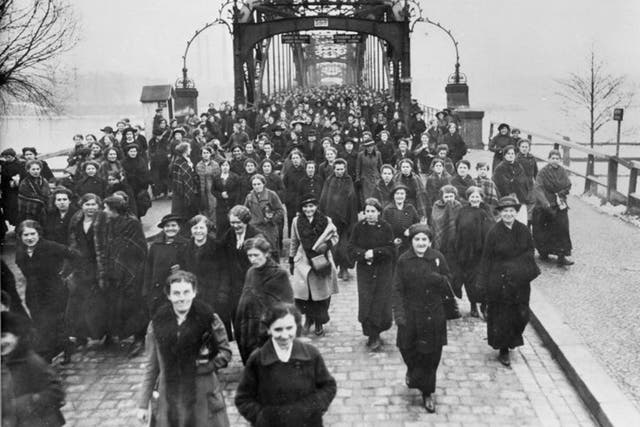 Women leaving a munitions factory on Eiswerder Island in Spandau, near Berlin, at the end of their shift, in around 1917. They are crossing the bridge over the river Havel