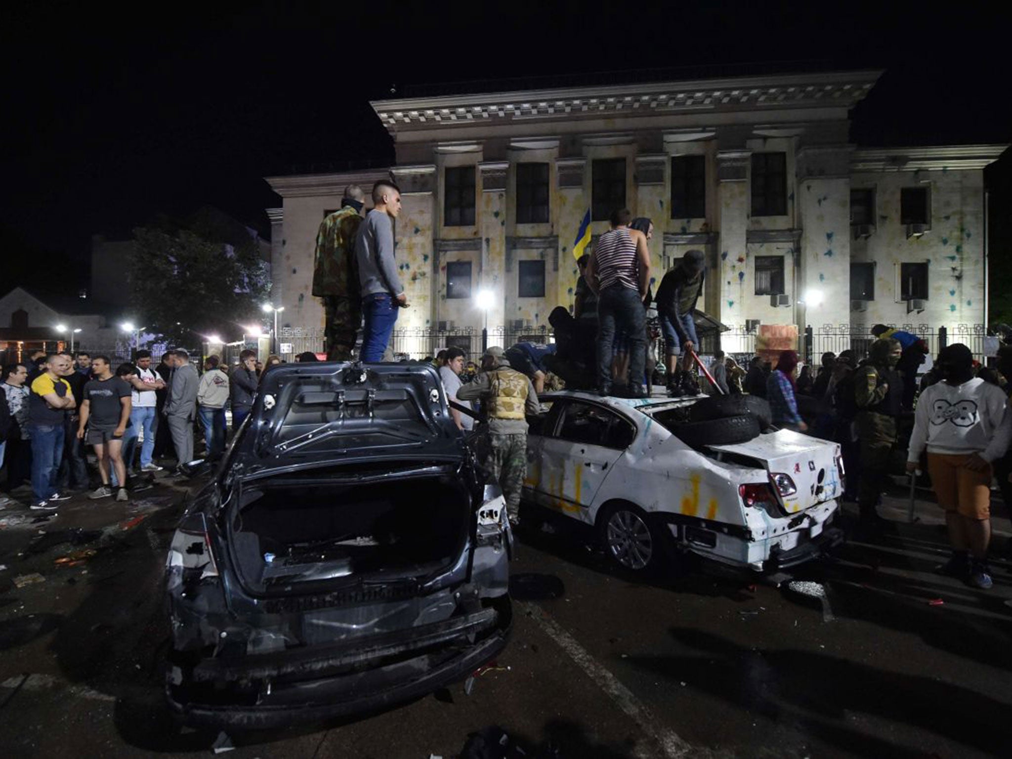 Demonstrators stand on top of crashed diplomatic cars during the protest in front of the Russian embassy in Kiev yesterday following the downing of a Ukrainian plane