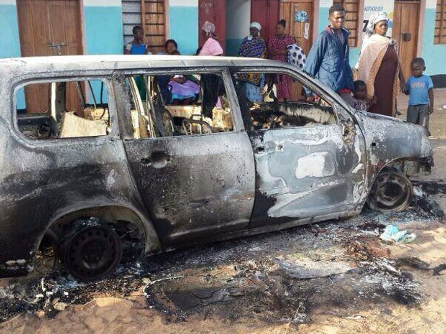 People gather around the wrekage of a car in Mpeketoni, in Lamu county along the Kenyan coast