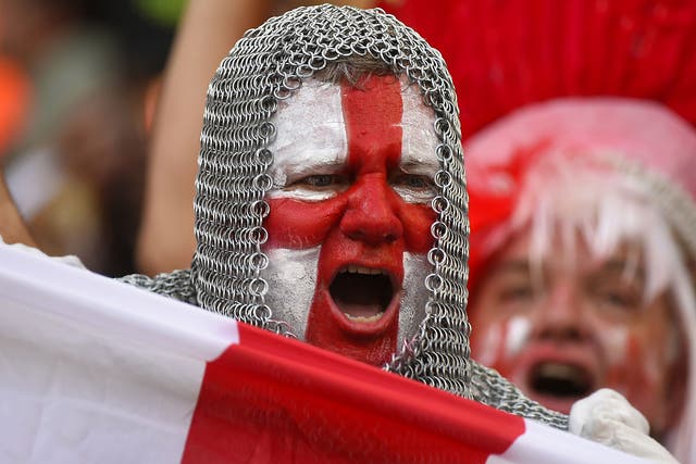 An England fan with his face painted in the colours of his national flag and wearing a chain mail costume cheers prior to a football match between England and Italy