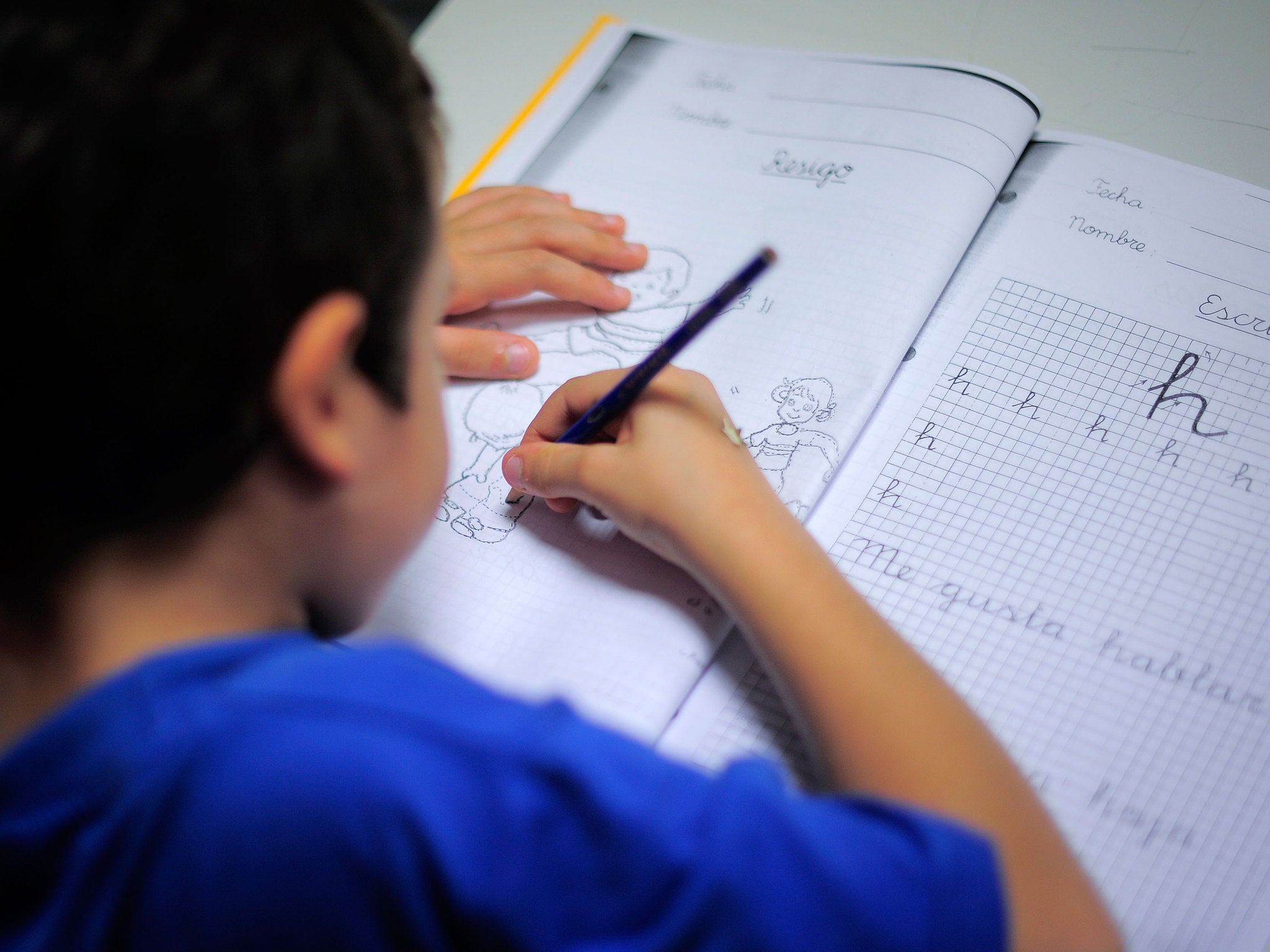 A young boy from a financially troubled family does his homework at the care centre Marti-Codolar in Barcelona on November 21, 2012 where he spends his afternoons with other children. Children from many families brought close to poverty by Spain's economic crisis benefit from free care services such as this free evening learning centre.