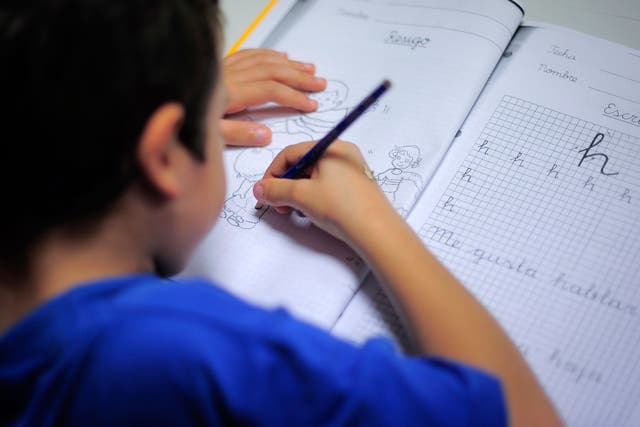 A young boy from a financially troubled family does his homework at the care centre Marti-Codolar in Barcelona on November 21, 2012 where he spends his afternoons with other children. Children from many families brought close to poverty by Spain's economic crisis benefit from free care services such as this free evening learning centre.