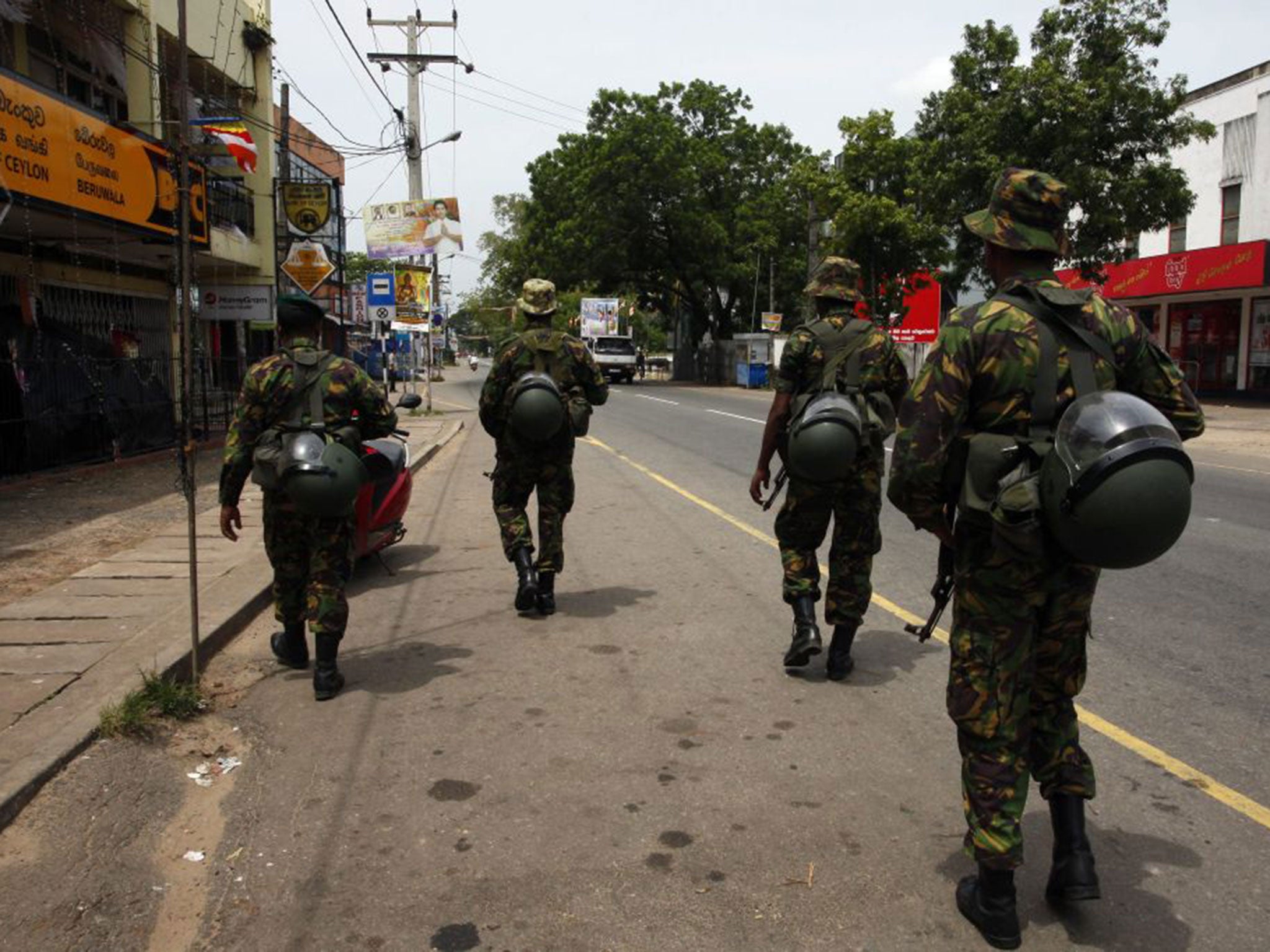 Sri Lanka Police Special Task Force personnel patrol deserted roads following sectarian violence in Aluthgama, 60 kilometers south of Colombo