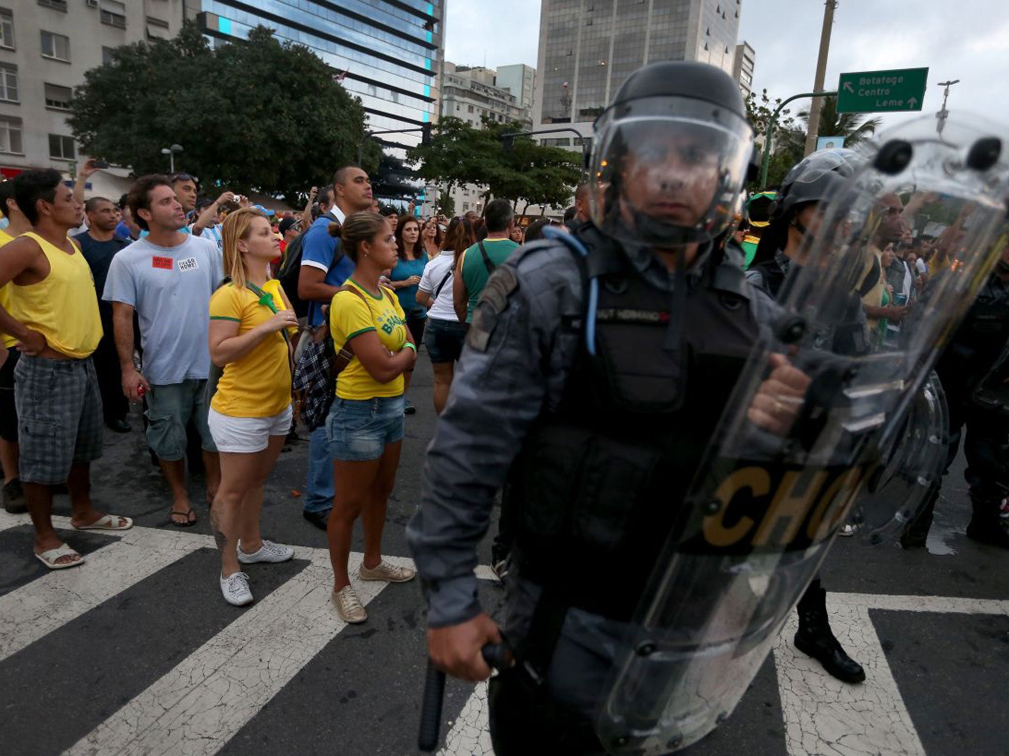 Fans flanked by riot police watch Brazil play on giant screens
