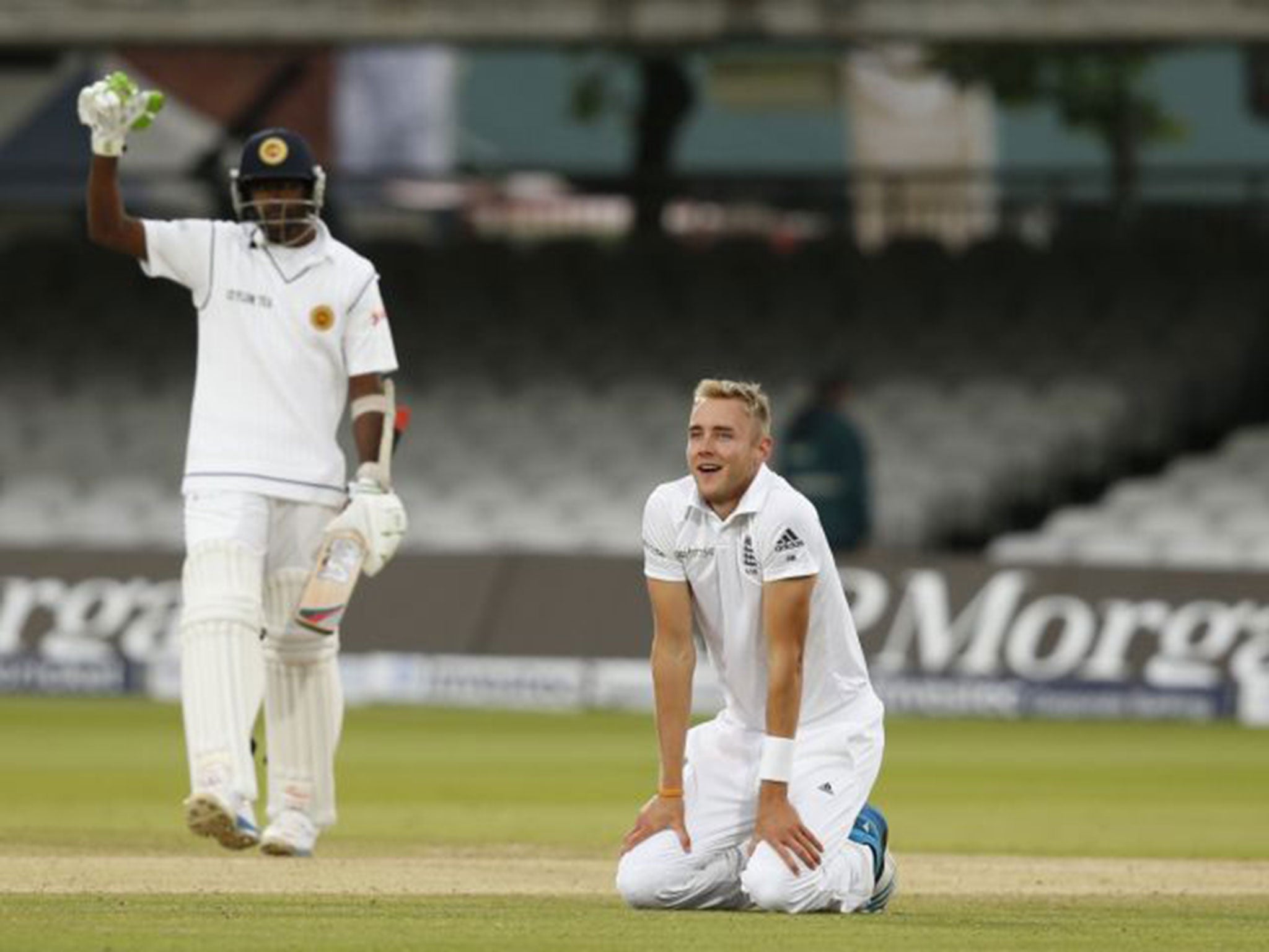 A dejected Stuart Broad sinks to his knees as England narrowly fail to take the last Sri Lanka wicket (AP)
